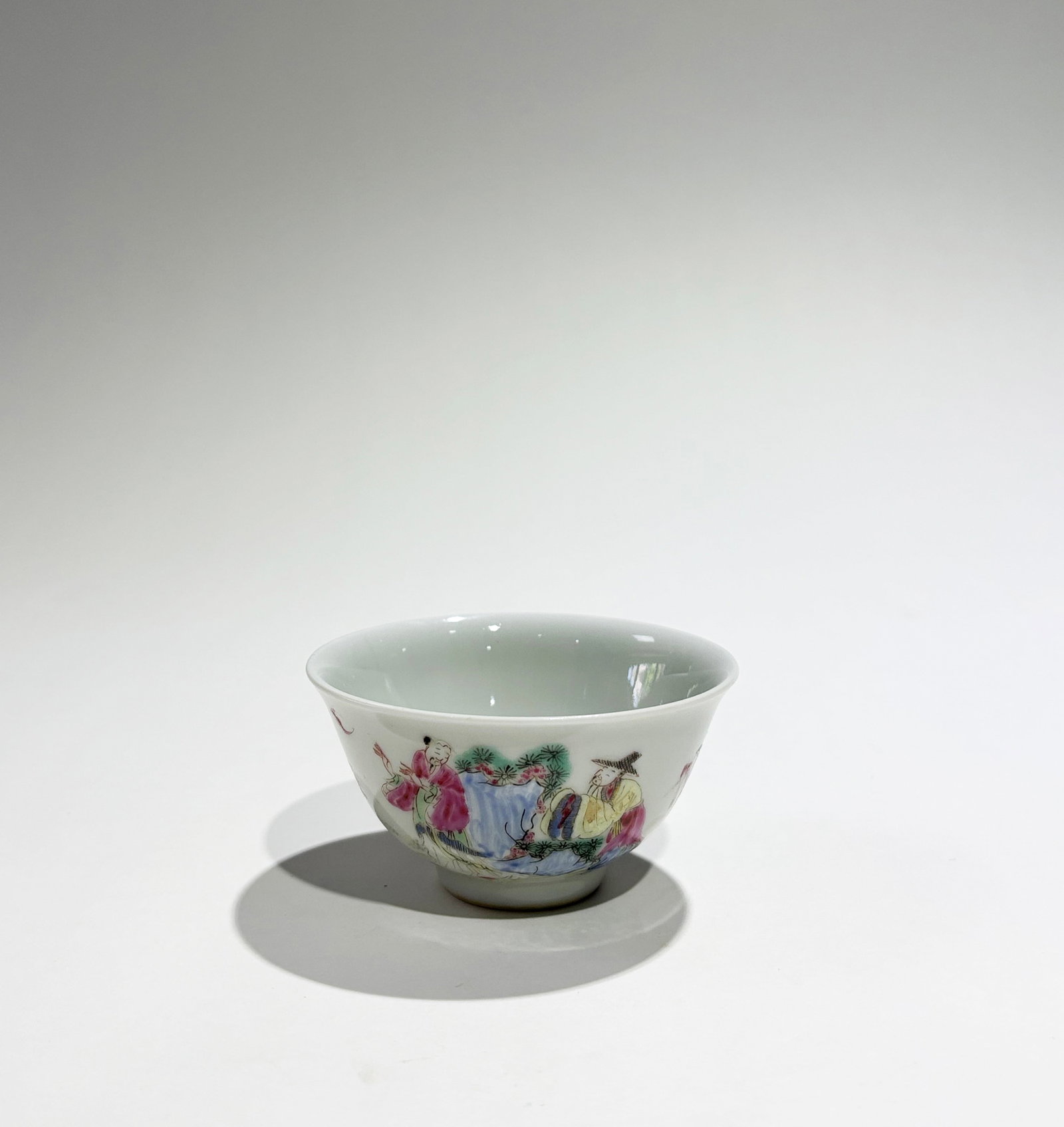 Chinese Famille Rose Enameled Porcelain Cup: Chinese Famille Rose Enameled Porcelain Cup with Scholars in a Garden with assistants, Pine, Deer & Lingzhi, the recessed base with 6 character Yongzheng mark inside double squares all in underglaze b