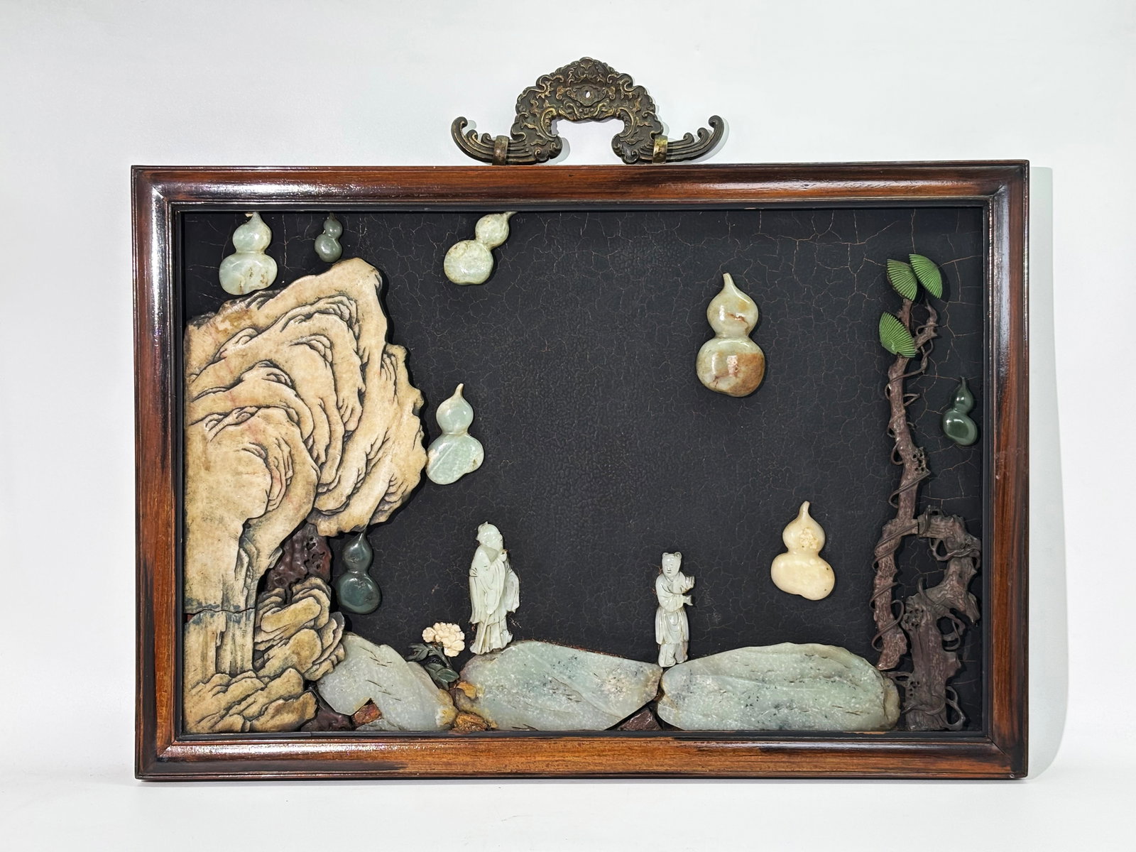 Chinese 18th/19th C Jade Inset Lacquer Panel: Chinese 18th and 19th Century Jade Inset Lacquer Panel in a hard wood frame held by a large bronze descending Bat hanger to top center; the scene with Antique Jade Carvings of Rocks, Boulders, descend