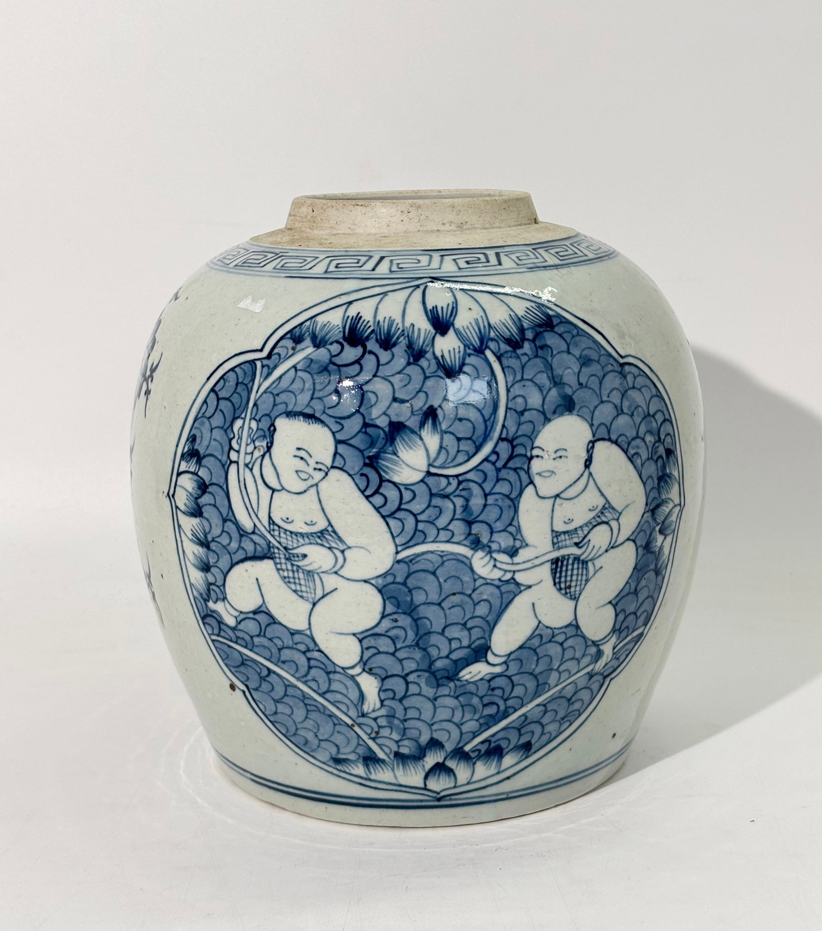 Chinese 19th C Blue & White Porcelain Ginger Jar: Chinese 19th Century Blue & White Porcelain Ginger Jar with quatrefoil windows front and back with 2 Baby Boys with Lotus, the sides with flowers; te recessed base in clear glaze. Height 8 3/4 inches 