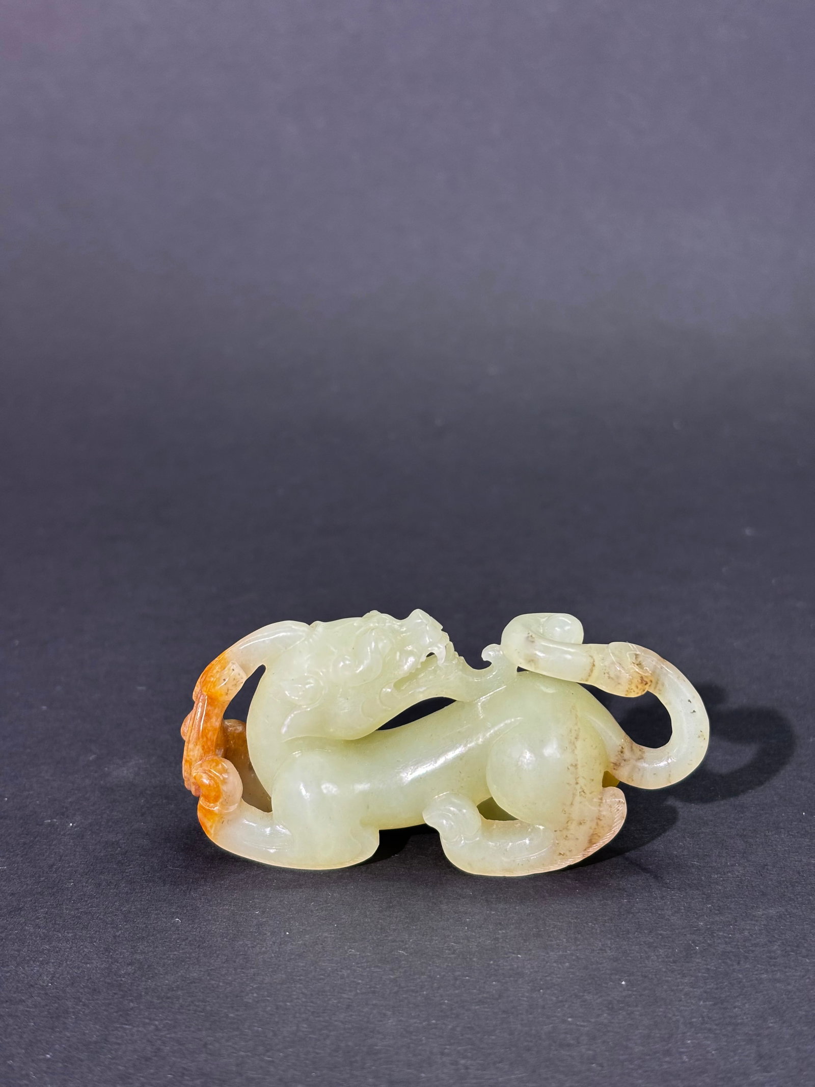 Fine Chinese Pale Celadon & Russet Jade Dragon: Fine Chinese Pale Celadon & Russet Jade single Horned Dragon with double tail, the fierce face well carved with open mouth, tongue and fangs the 4 feet with long polished claws and with small hairline