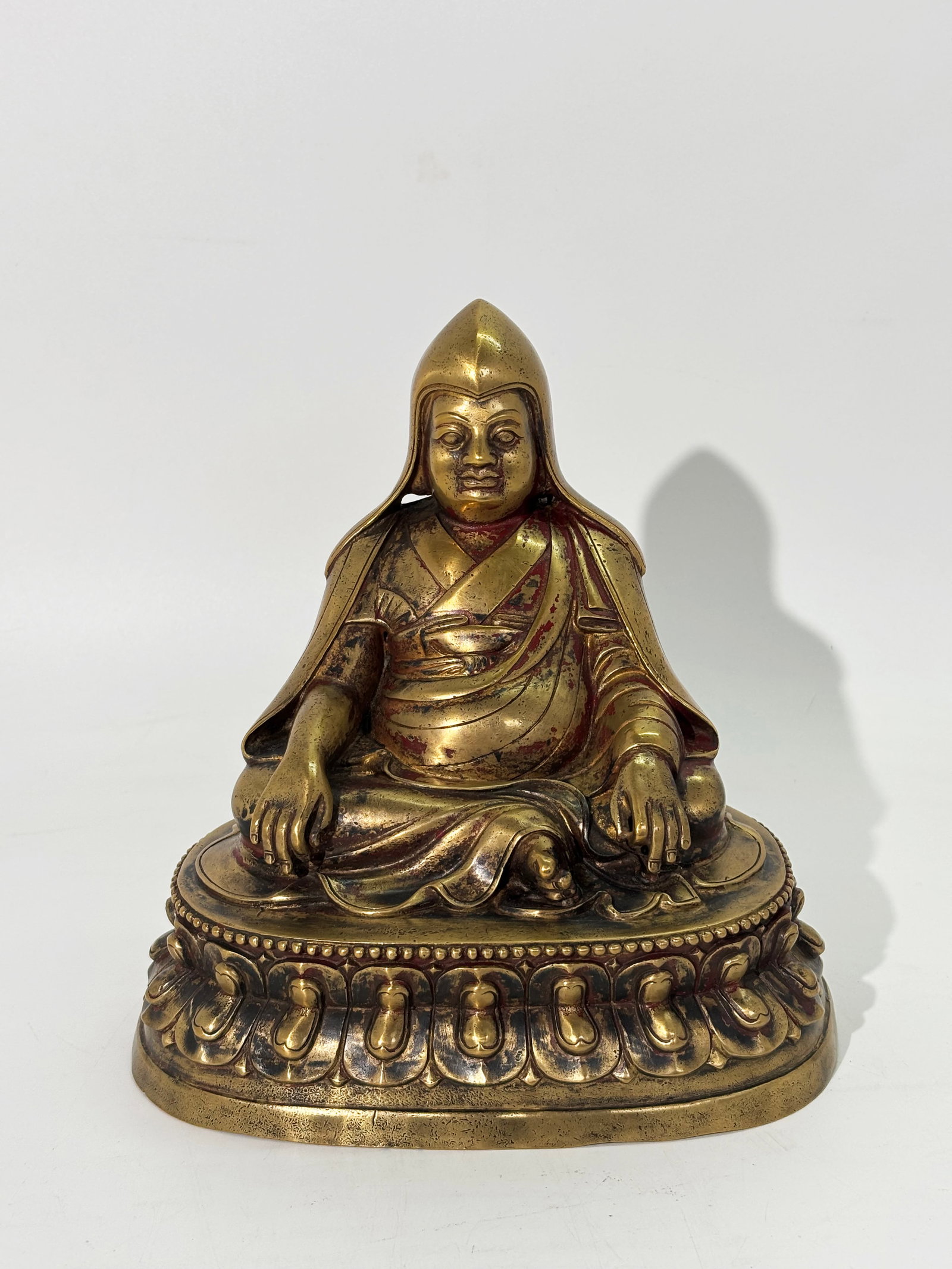 Tibetan Bronze Lama Seated Double Lotus Throne: Tibetan cast & incised Bronze Lama Seated on an opened Double Lotus Throne with a Tibetan inscription to back of throne top; traces of red cold painting. Height 7 3/4 inches X width at base 7 3/4 inch