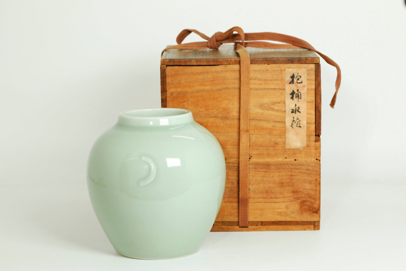 Chinese Celadon Monochrome Porcelain Jar: Chinese Celadon Monochrome Porcelain Jar, the sides carved with "C" shaped crescent-moon handles under the glaze; the inside and recessed base in celadon with a 6 character Qianlong seal mark to botto