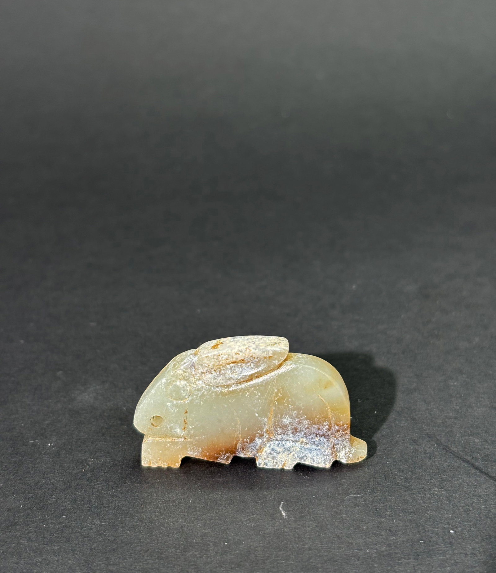Chinese Lt Celadon Jade Archaistic Animal Pendant: Chinese Pale Celadon, Brown & Calcified Jade Archaistic Animal Pendant, the animal carved to both sides with large ears and a long tail and drilled at the nose for suspension. Height 1 inch X width 1 