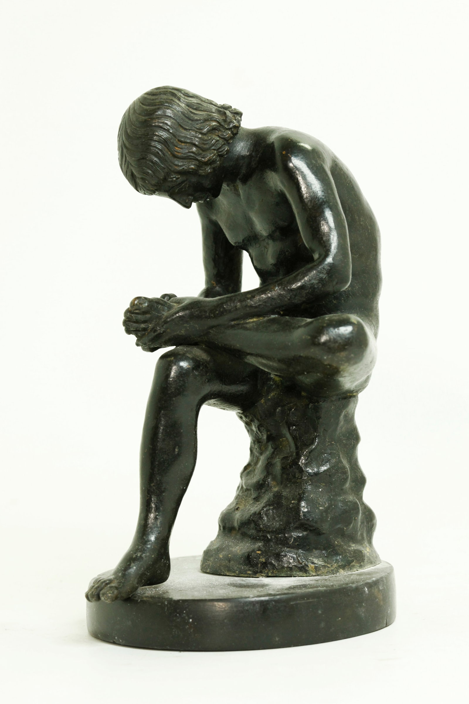 Italian Cast Metal Sculpture Spinario Boy & Thorn: Italian Cast Metal Sculpture with a black patina; after the famous 1st century Roman sculpture in the Capitoline Museum in Rome known as The Spinario (Boy with Thorn); mounted on a round stone base. H