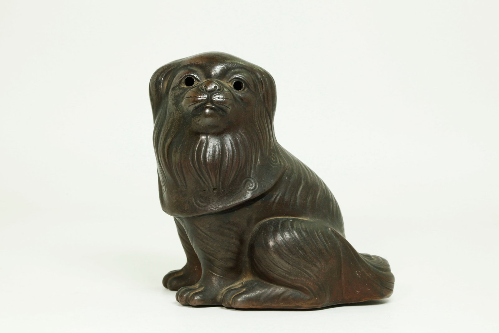 Japanese Antique Bizen Stoneware "Pekingese" Puppy: Japanese Antique Bizen Stoneware "Pekingese" Puppy with hollow eyes, details to fur & face and wearing a ruffled bib tied in a bow at the back of the neck. Height 6 inches X width 5 3/4 inches.