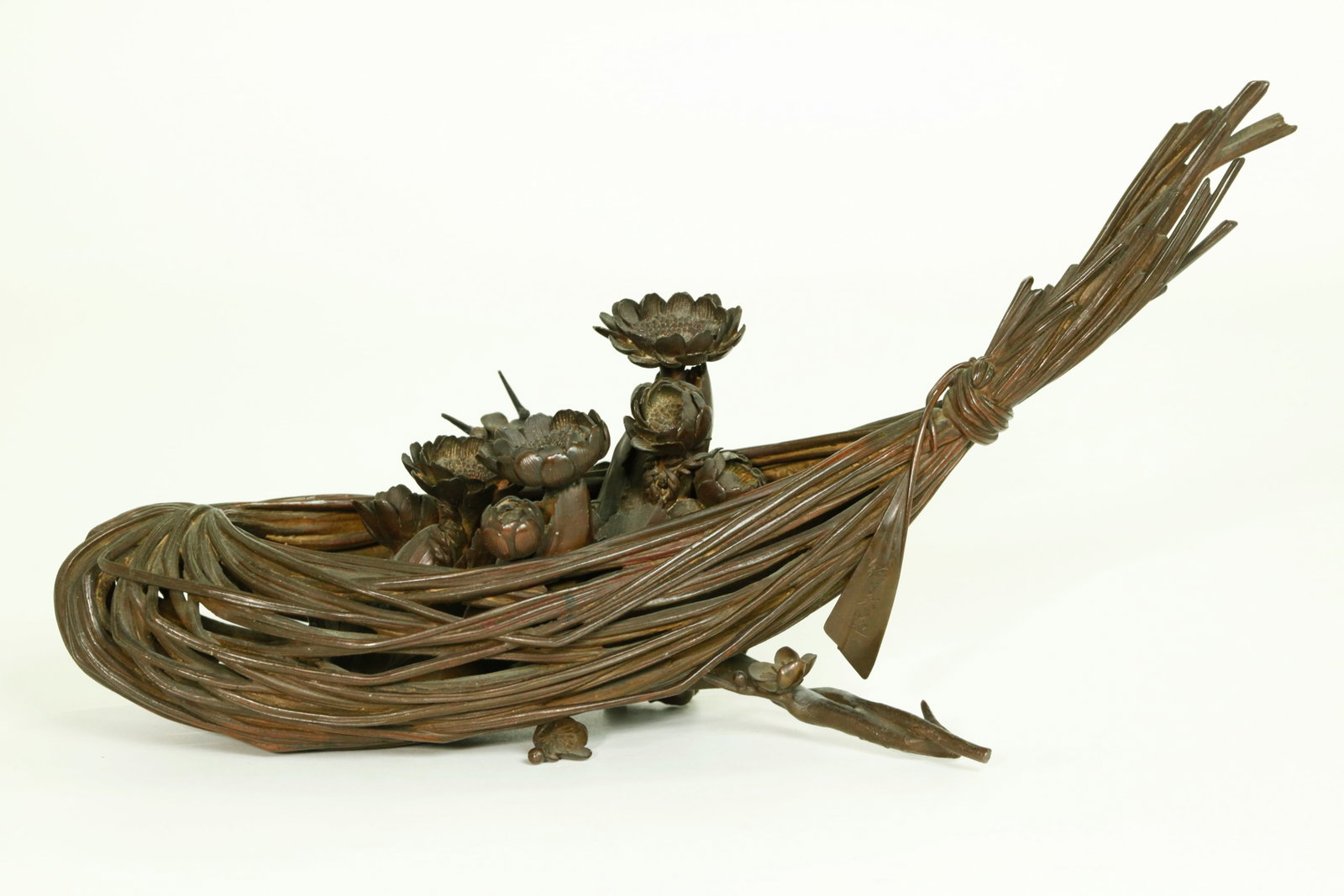 Japanese Shobi Zo Bronze Okimono Flower Basket: Fine Japanese Bronze Okimono of Flowering Bulbs in a tied stem Basket tied at both ends with an incised mark, "Shobi Zo" on a bronze tab at 1 end, a short flowering prunus branch across the base and u