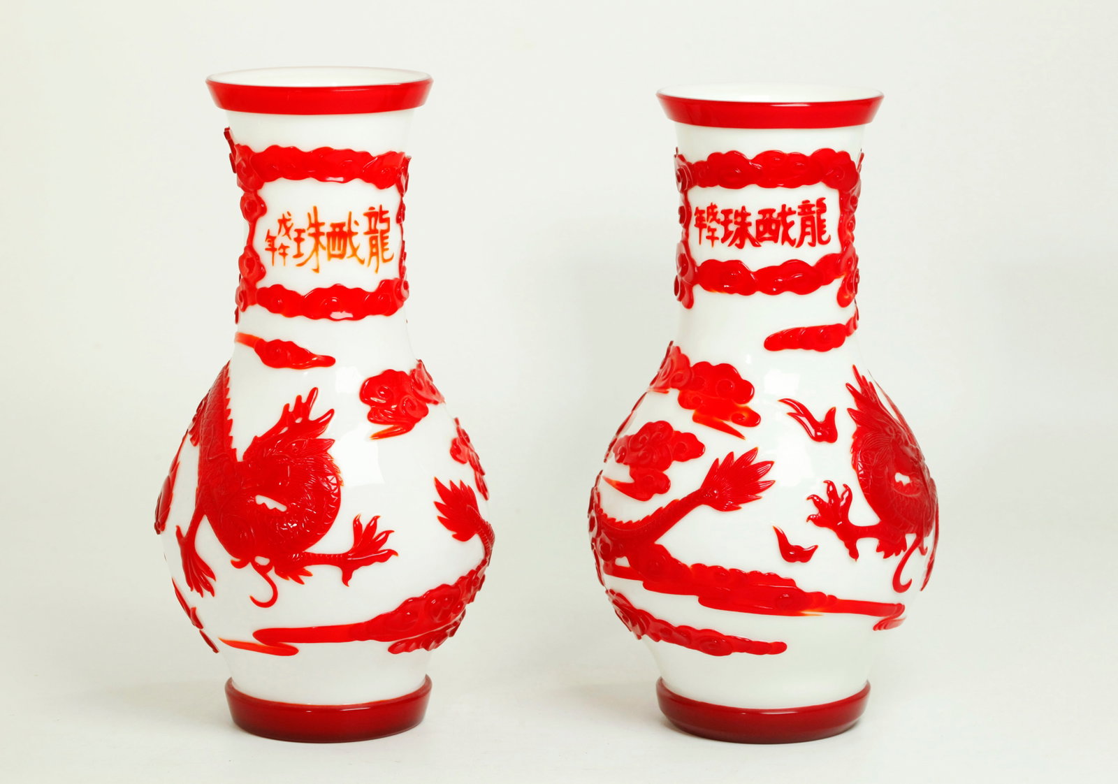 Pr Chinese Carved Red On White Glass Dragon Vases: Pair Chinese Red overlay on Milk White Glass Vases each blown, carved and polished with an opposing red Dragon and Flaming Pearl with connected red clouds around the neck forming a window with carved 