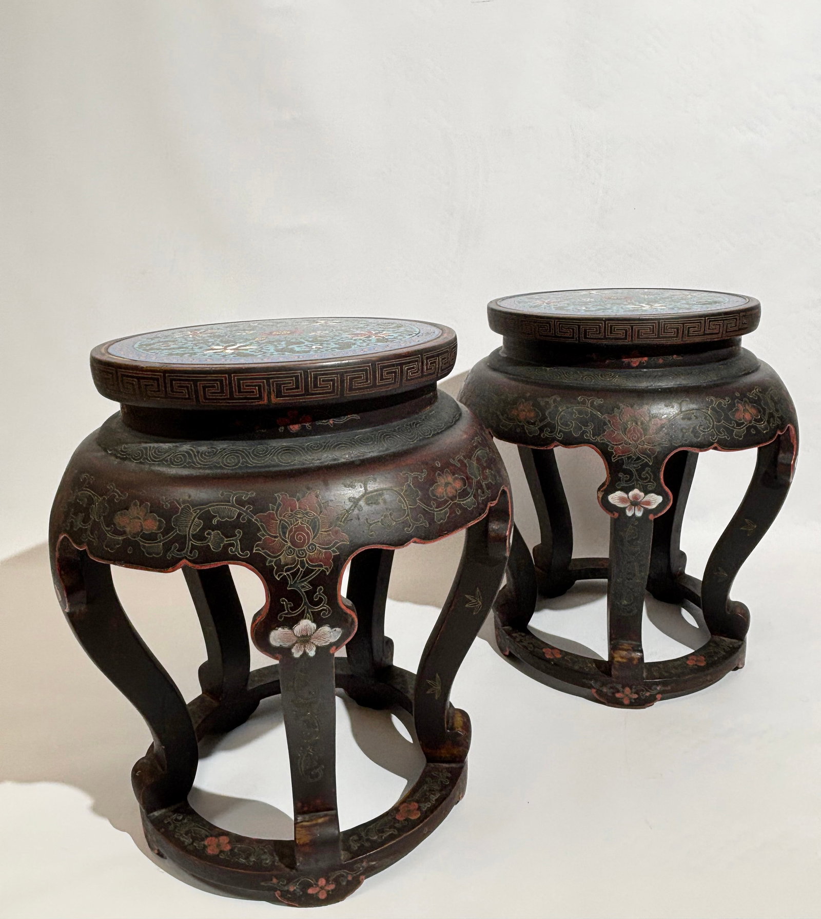 Pr Chinese Cloisonne & Tianqi Lacquer Stools: Pair Chinese Tianqi floral incised Lacquer round Stools or Low Tables with shaped skirts over 5 curved feet with a ring brace near bottom, the top inset with a round cloisonne disc enameled with color