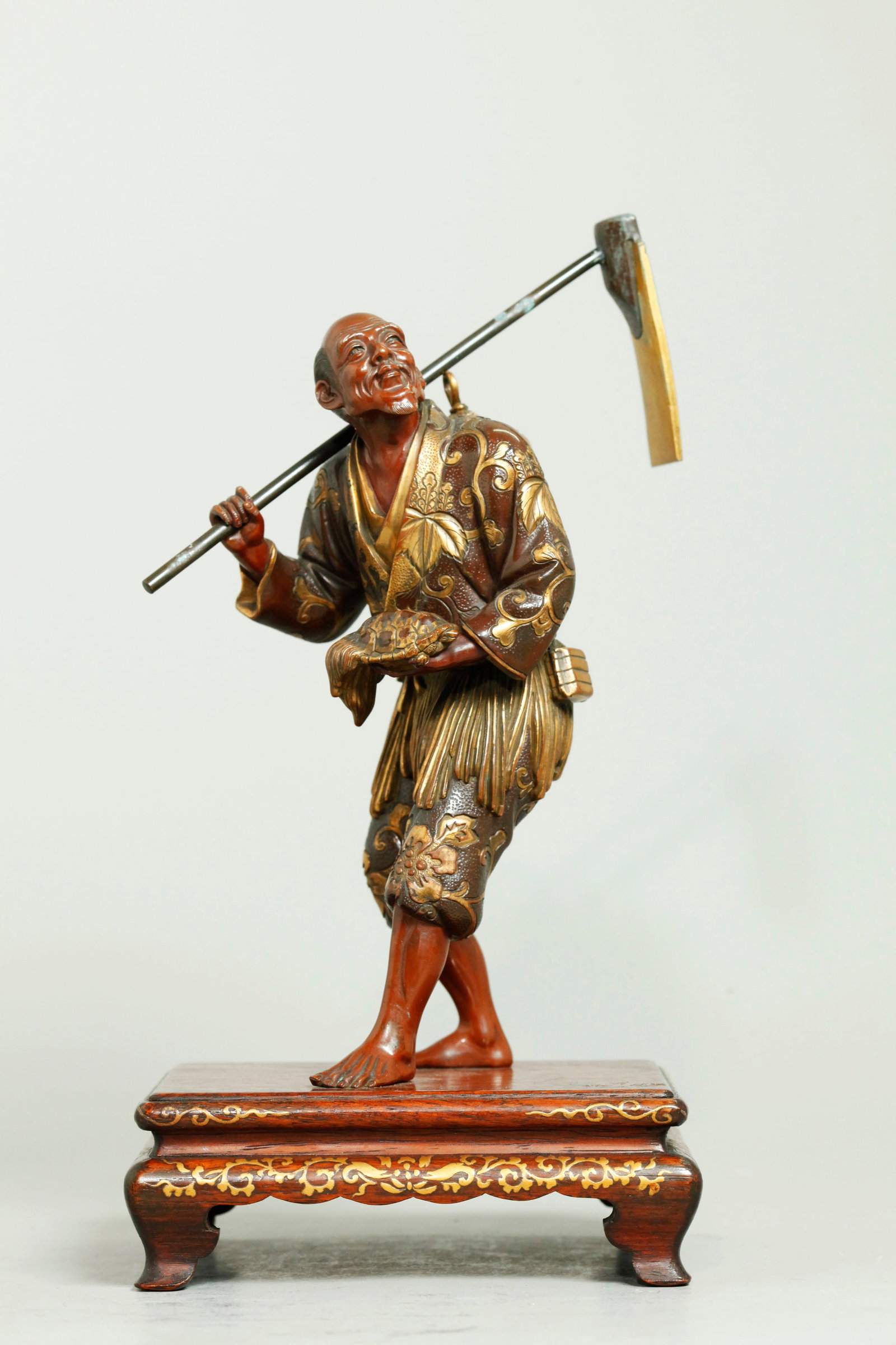 Japanese Meiji Bronze Okimono Farmer, Kuwa & Pet: Japanese Meiji Copper Alloy Okimono of a Farmer in gold patterned clothing holding a Kuwa Hoe Tool over his right shoulder and with a Pet "long life" Minogame, with a small calligraphy plaque to back 