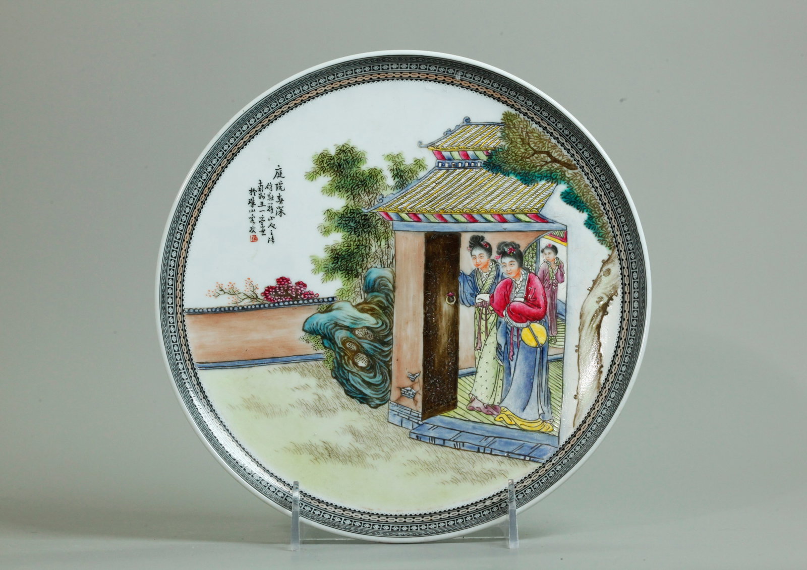 Chinese Enameled Porcelain Display Plate: Chinese Enameled Porcelain Display Plate with a design of Ladies opening the doors to a Garden, with calligraphy, the bottom with a red seal mark and with 3 original holes to foot ring for suspension.