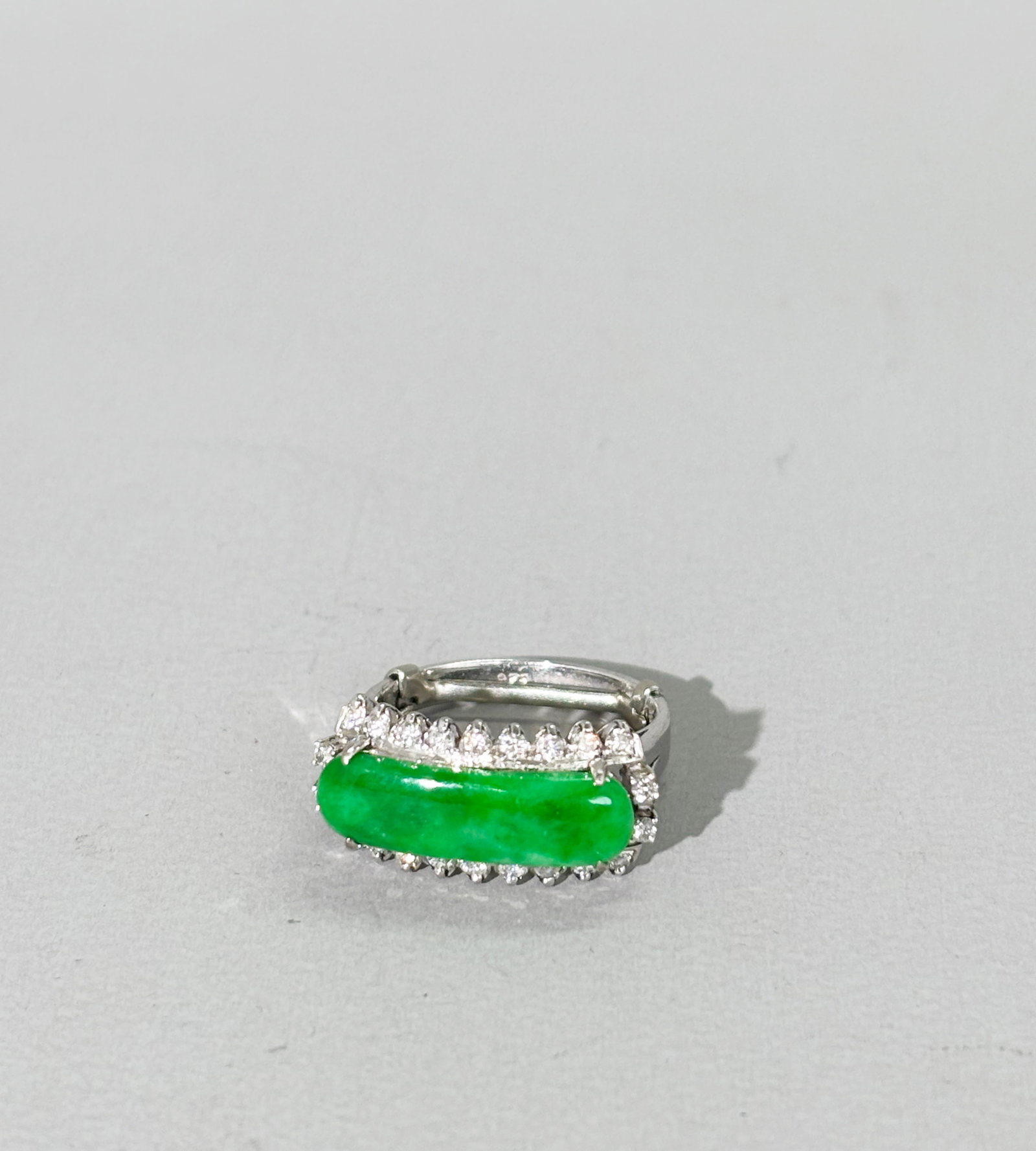 Chinese Apple Green Jadeite Saddle & Diamond Ring: Chinese translucent Apple Green Jadeite Saddle-shaped stone prong set in white metal probably gold or platinum marked "226" with 22 small Diamonds. US ring size with metal size reducer inside band 5. 