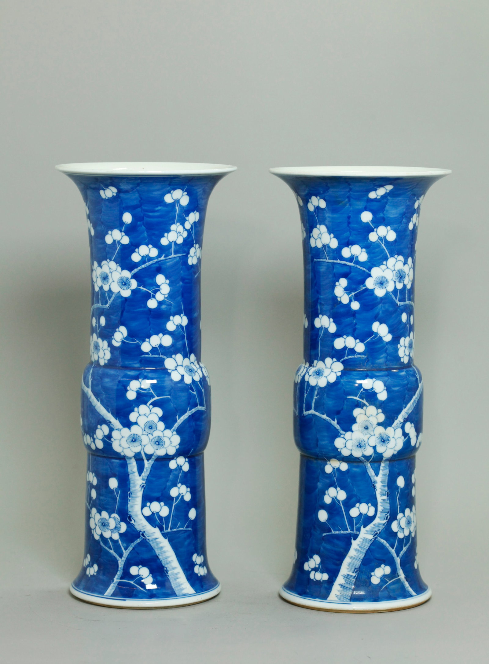 Pr Chinese Qing Blue White Porcelain Prunus Vases: Pair Chinese Qing Dynasty Blue White Porcelain Prunus "Gu" Vases with a mirror design of white Prunus flowers and white branches on a mottled blue ground, the recessed bases in clear glaze with 4 char