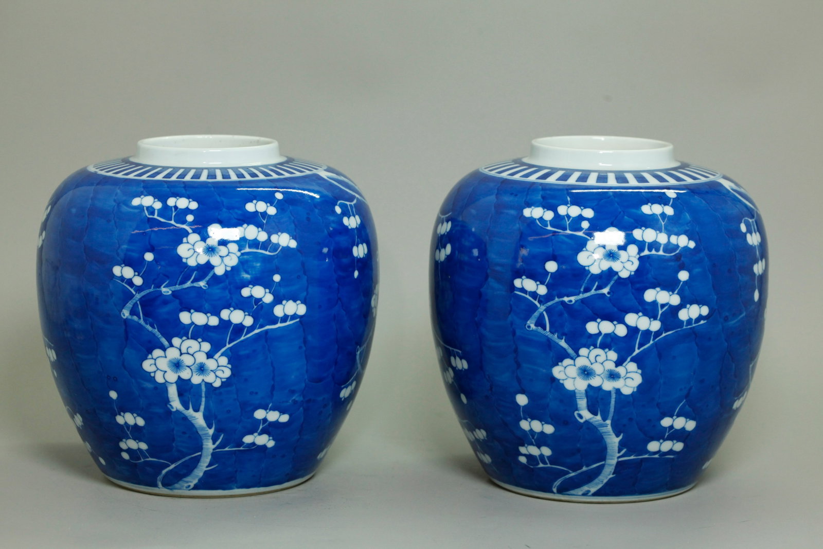 Pr Chinese Blue White Porcelain Prunus Ginger Jars: Pair Chinese Qing Dynasty Blue & White Porcelain Prunus Ginger Jars with white stems and flowers on a mottled blue ground with a crenelated border around mouth, the bases in clear glaze with double ri