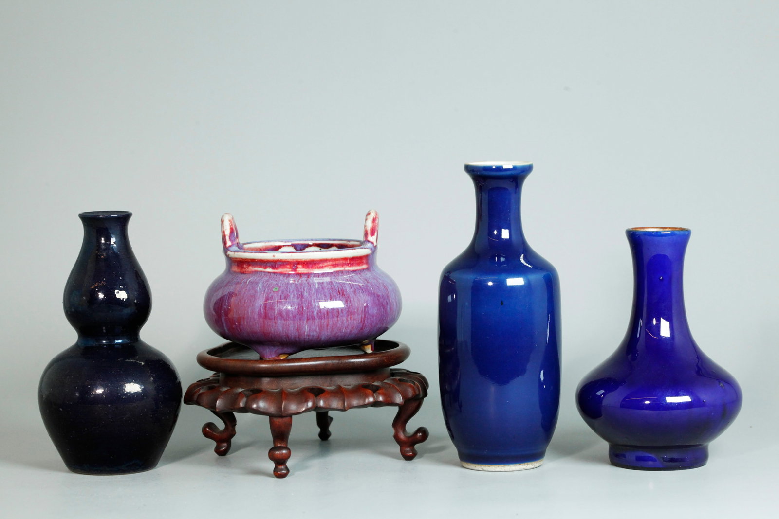 4 Chinese Porcelain Monochromes 3 Vases 1 Censer: 4 Chinese Porcelain Monochromes: 3 Vases, 2 in cobalt blue and 1 double gourd in dark purple-blue; together with a red & flambe crackle glazed Censer on 3 feet with 2 loop handles rising from the mout