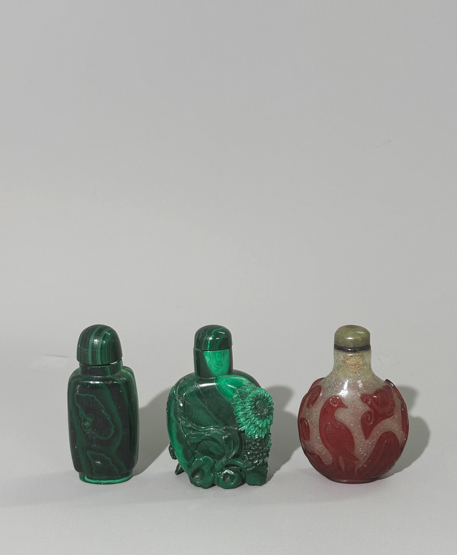 3 Chinese Snuff Bottles 19C Overlay 2 Malachite: 3 Chinese Snuff Bottles a 19th Century red glass Overlay on bubble suffused clear glass carved with Dog & Bat to 1 side and Hawk and Moon to the reverse with a clean red polished oval foot ring and wi
