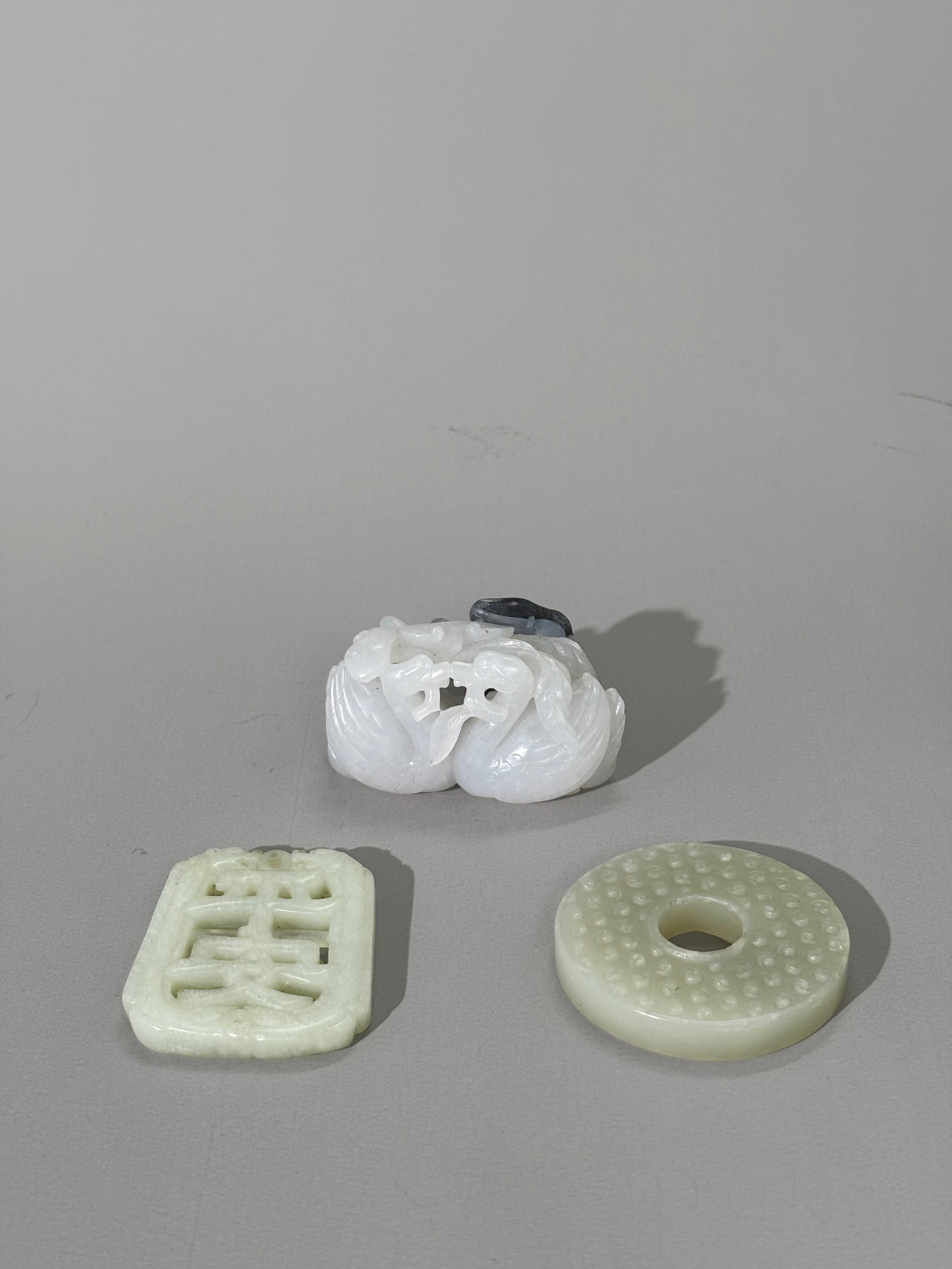 3 Chinese Jades: Black & White Geese & 2 Pendants: 3 Chinese Jades: a complex White Jade carving of 3 Geese with lotus root with each goose holding Lingzhi in its beak with 1 goose part carved in a passage of black to gray jade holding black to gray L