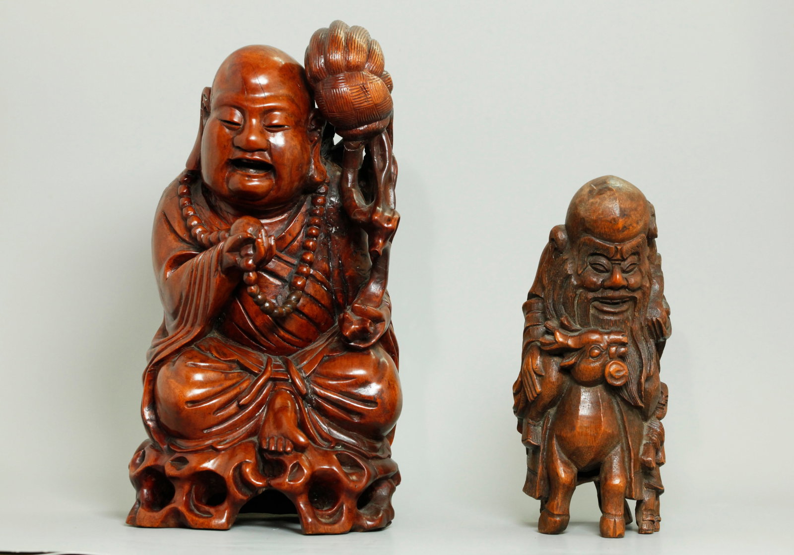 2 Chinese Qing Carvings: Wood Lohan Bamboo Shoulao: 2 Chinese Qing Dynasty Carvings: a solid carved and polished yellow Hard Wood Lohan with life-like facial expression, seated on a pierced rock saying his rosary and holding a Buddhist Fly Whisk; toget