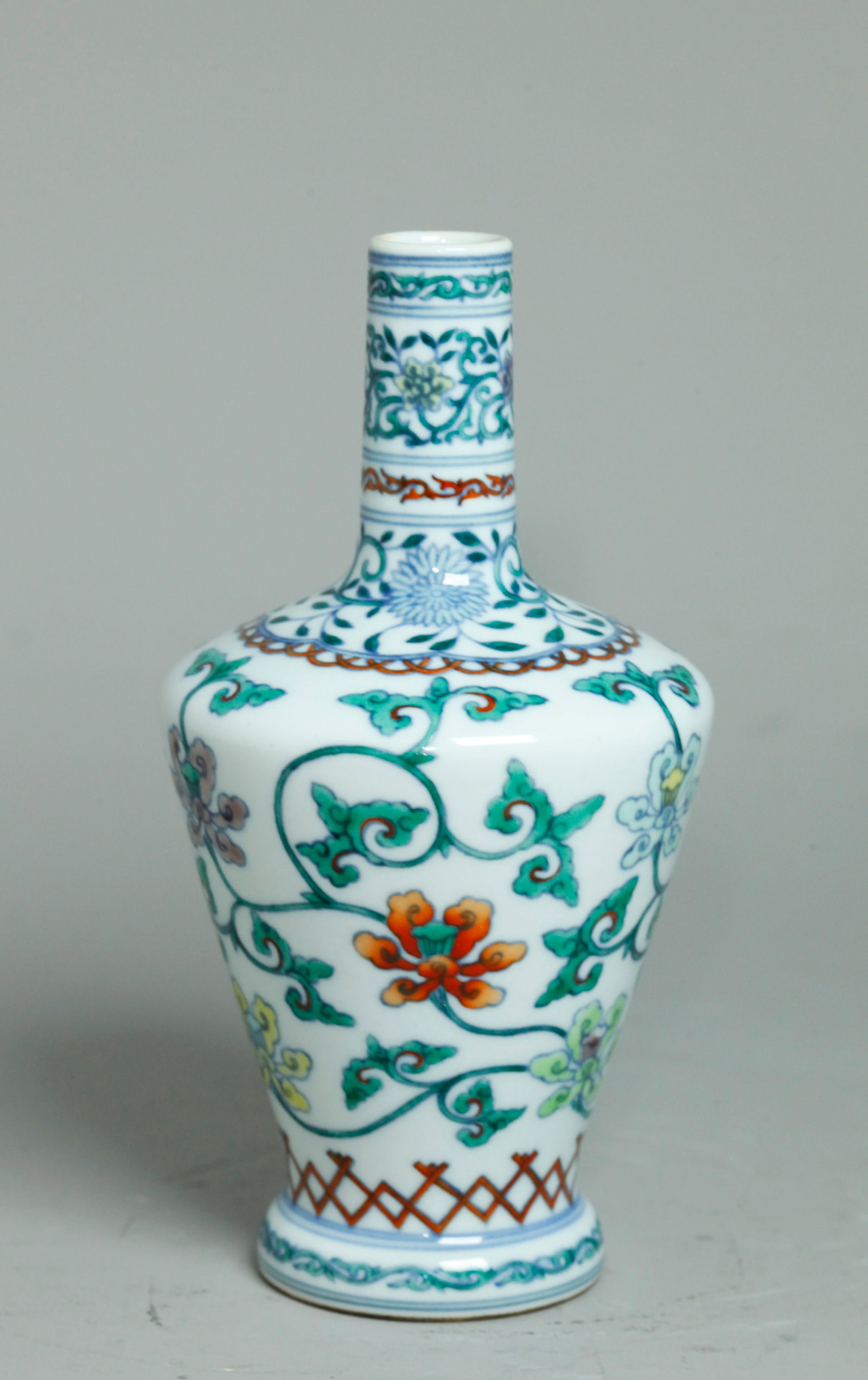 Chinese Doucai Enameled Porcelain Bottle Vase: Good Chinese underglaze blue and Doucai Enameled Porcelain Bottle Vase with three bands of scrolling flowers between ribbon bands; the clear glaze stepped recessed bottom with 6 character horizontal Y