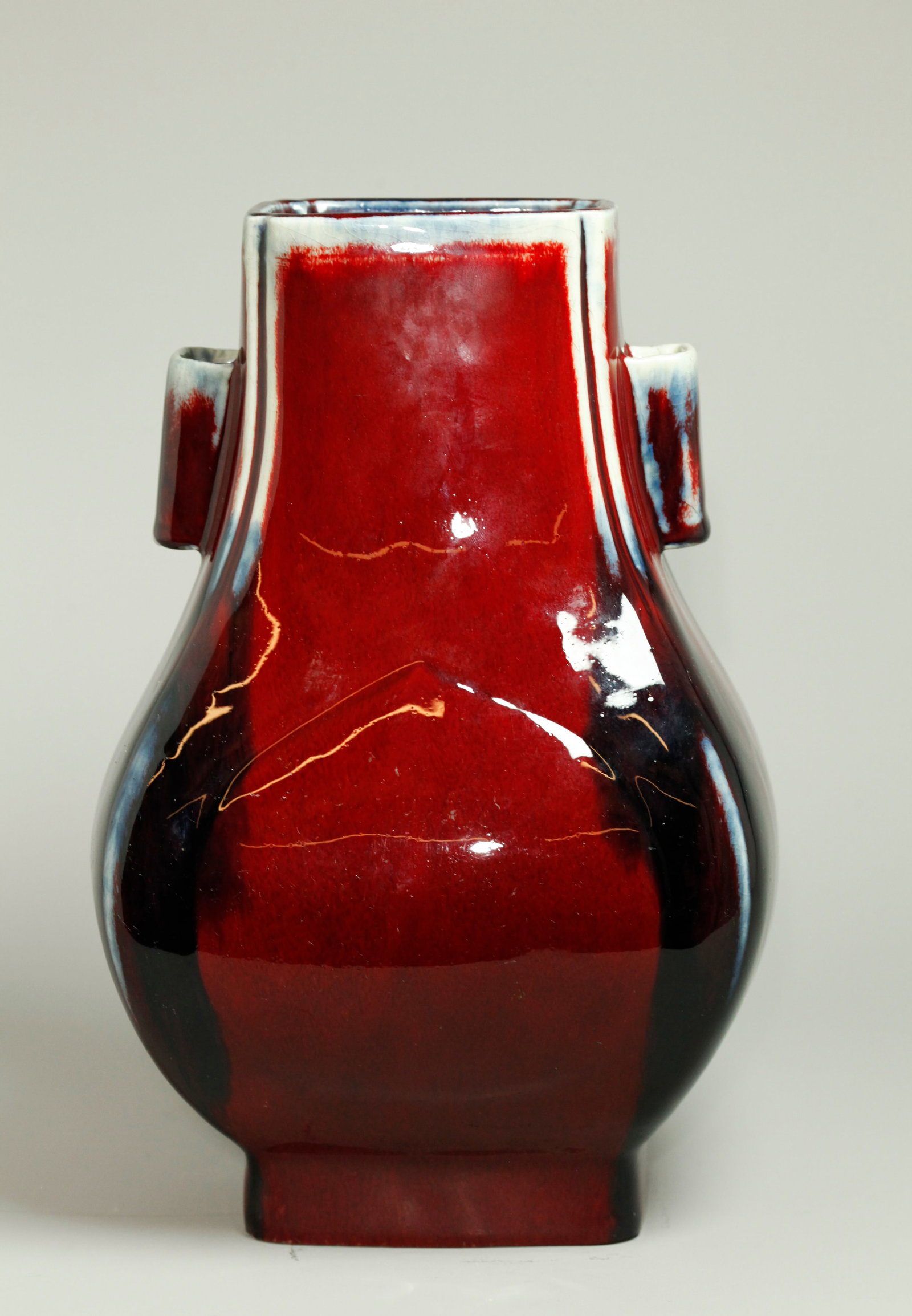 Fine Chinese Red & Blue Porcelain Fanghu Vase: Fine Chinese Underglaze Red & Blue Flambe crackle Porcelain Fanghu Vase with squared hollow lug handles to the neck, with raised peach shape to front and back, the thick glazes thinning to pale celado