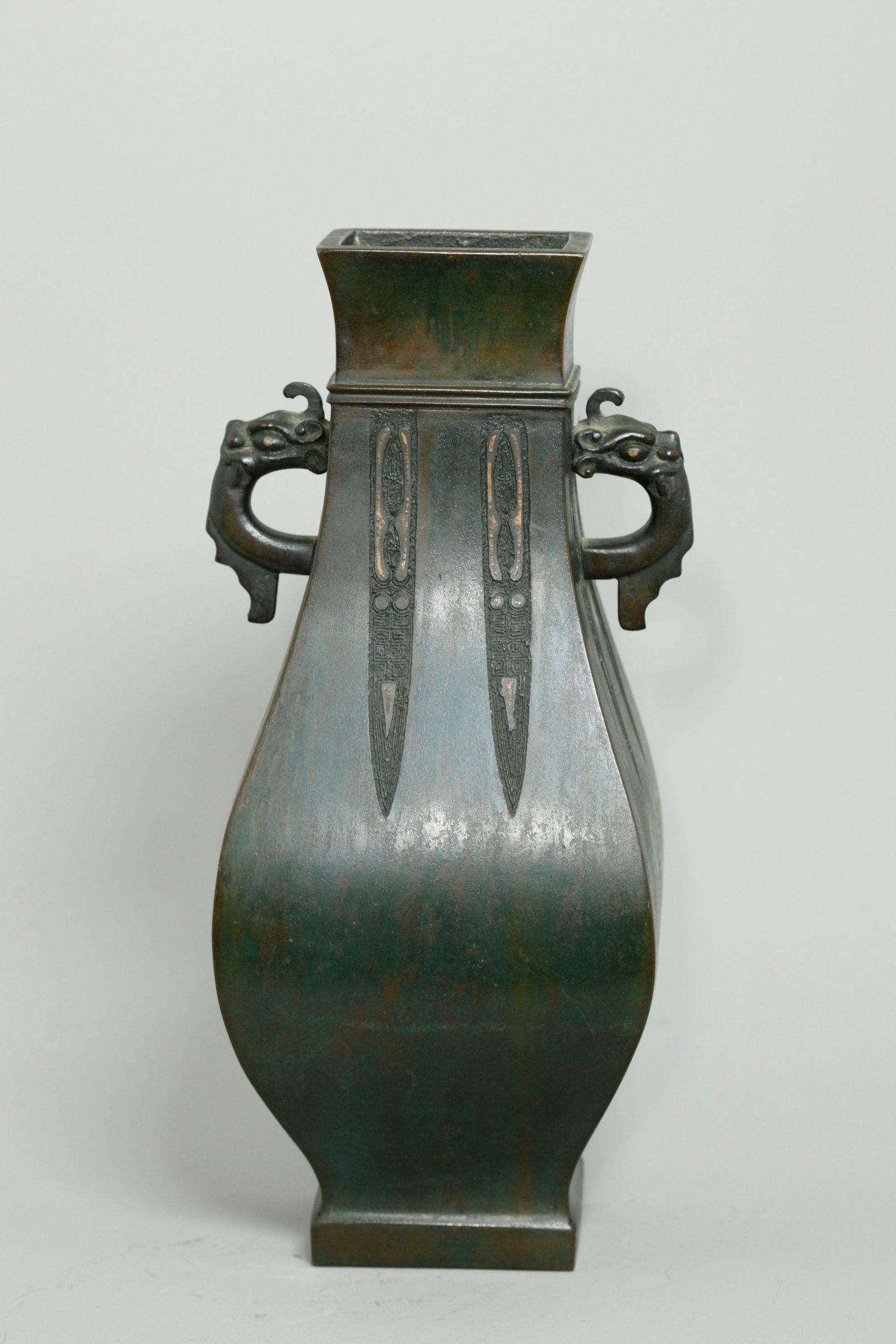 Chinese 18/19 C Archaistic Bronze Gold Foil Vase: Chinese 18th or 19th Century Bronze & Gold Foil inlaid 4-panel Vase with horned Dragon Head & Tongue Handles with gilt eyes, the 4 sides with pendant archaistic cast designs with shaped foil inlay, th
