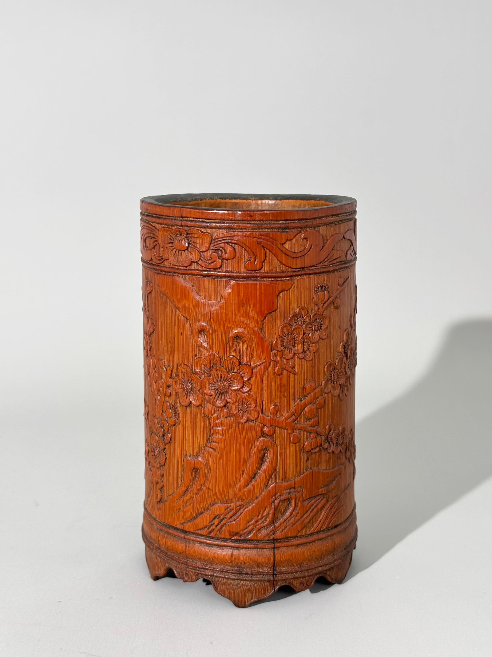 Chinese Late Qing Carved Bamboo Bitong Brush Pot: Chinese Late Qing Carved Bamboo Bitong Brush Pot, the outsides with a design in low relief of flowering Prunus branches at a Garden Rock and raised calligraphy between a band of flowers at the mouth a