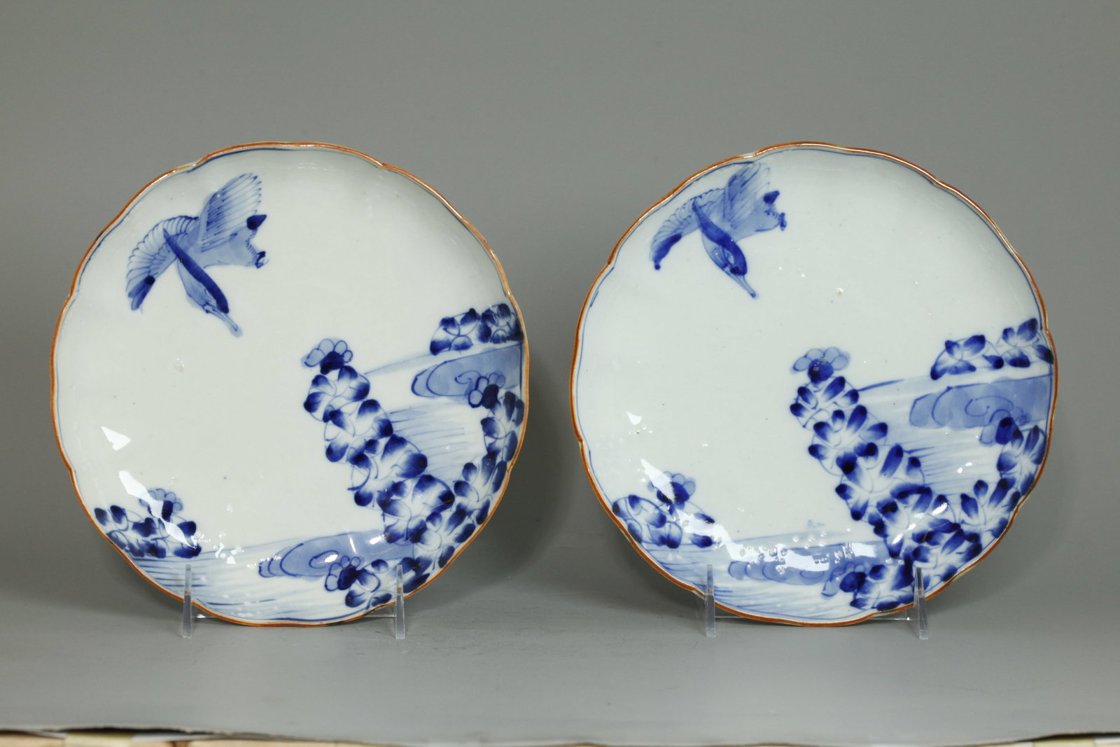 Pr Japanese Late Edo Blue & White Porcelain Plates: Pair Japanese Late Edo Period Blue & White Porcelain Plates with brown petal edge and a design of a Mandarin Duck flying over Water Hyacinths Height 1 1/4 inches X diameter 8 1/2 inches.