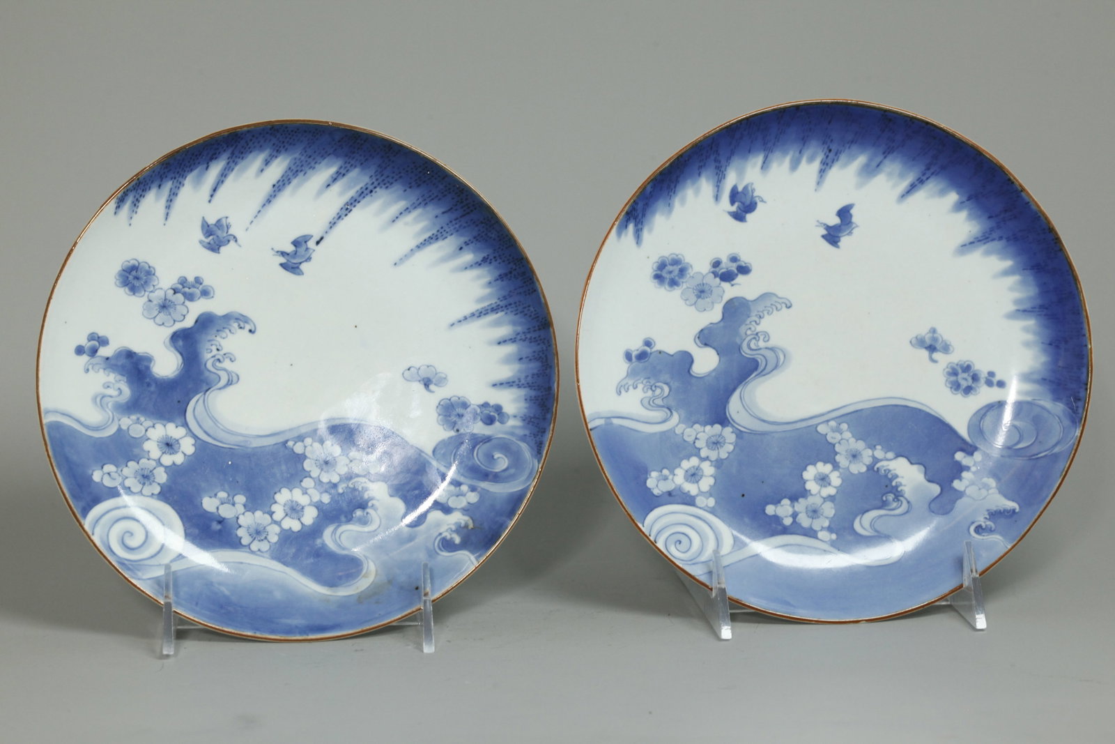 Pr Japanese Blue White Kakiemon Porcelain Plates: Pair Japanese 17th or early 18th Century Blue & White Kakiemon type Arita Porcelain Plates with 2 birds flying under willow leaves and over waves with fallen blossoms within a chocolate brown rim, the