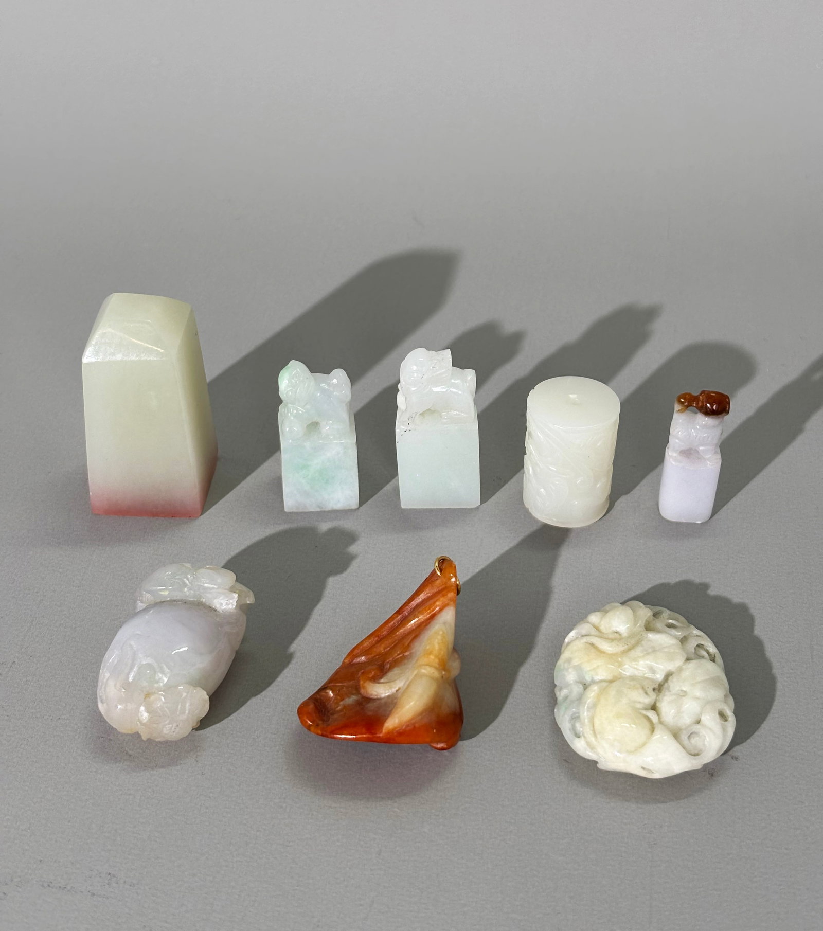 8 Chinese Carved Jade Jadeite Seals & Pendants: 8 Chinese Carved Jade or Jadeite Seals or Pendants: a warm white jade 4 sided seal with carved face with 3 miniature jadeite seals with polished faces and animal finials; a very white Chilong carved t
