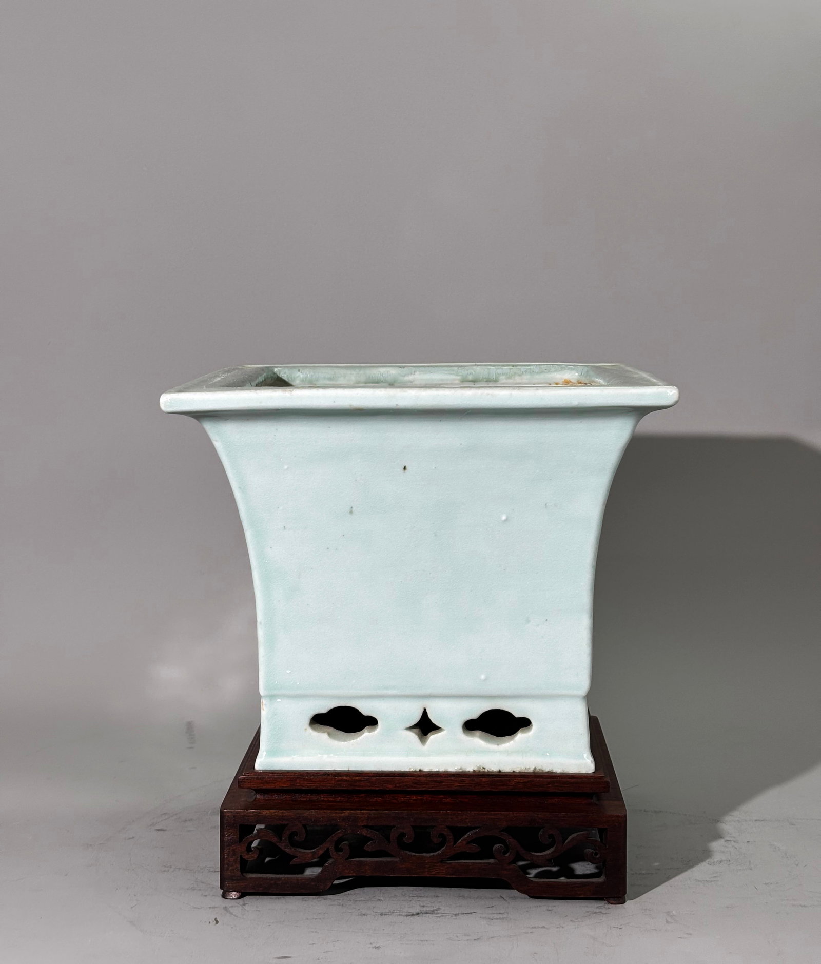 Chinese Qing Pale Celadon Porcelain 4 Side Planter: Chinese Qing Dynasty Pale Celadon Porcelain 4 Sided Square Planter with flaring sides over a pierced foot, the bottom unglazed with original drainage hole now with infill; together with a square hard 