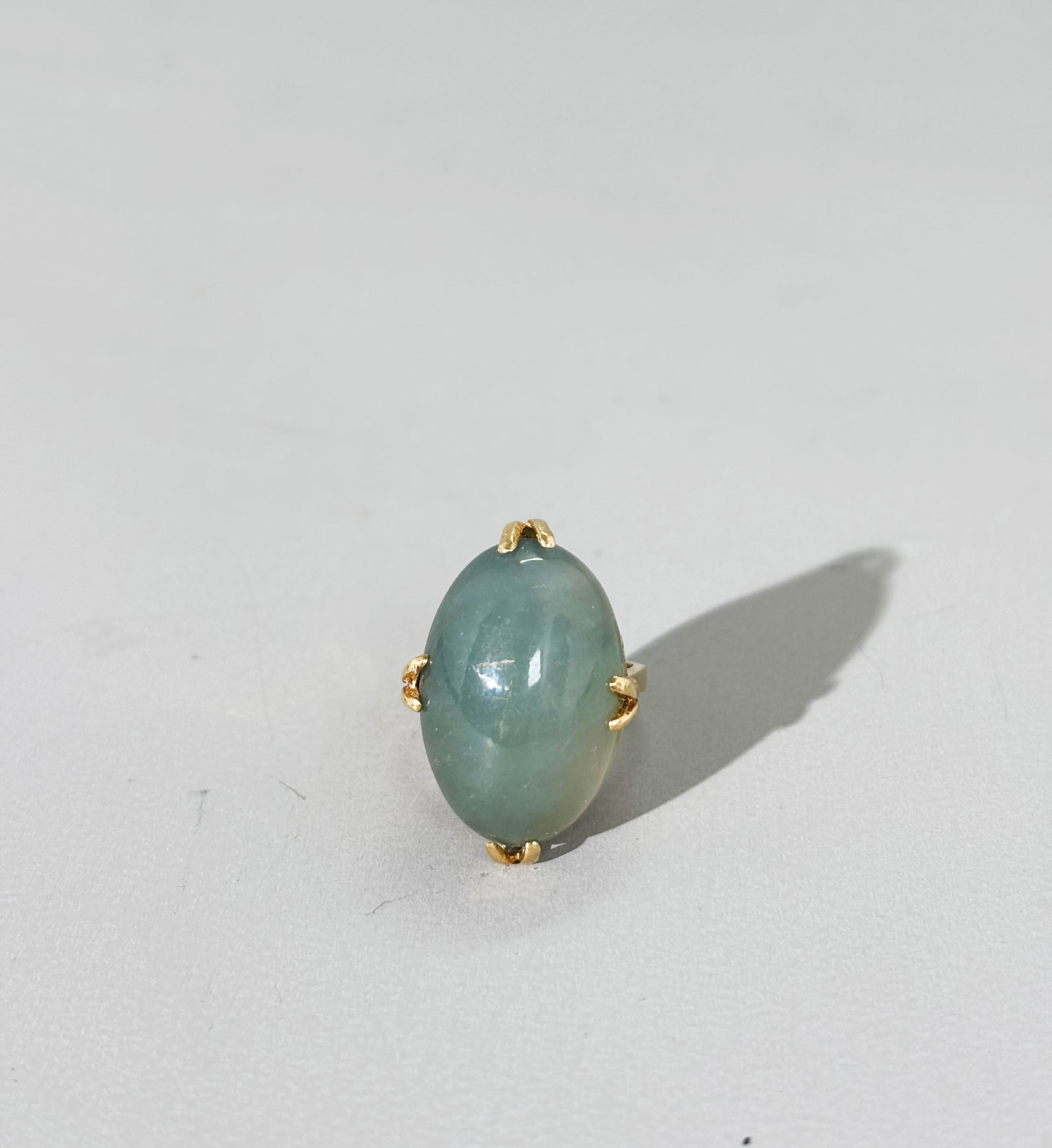 Chinese Qing Dynasty Icy Jadeite 14K Gold Ring: Rare Chinese Qing Dynasty Icy gray-green Jadeite cabochon with flat back and Bull-Nose holes formerly for Court Embroidery; now vintage mounted as a Ring prong set in yellow gold marked "14K" inside t