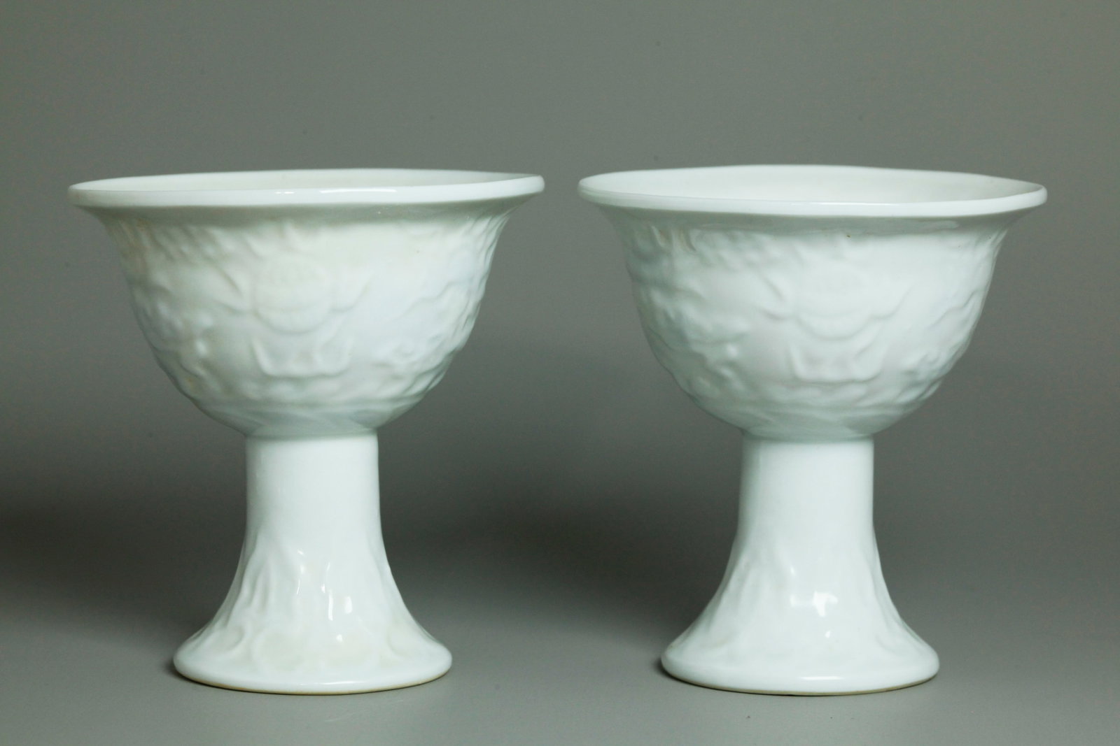Pr Chinese Hidden Blue Dragon Porcelain Stem Cups: Pr Chinese Hidden Dragon over molded Dragon Blanc De Chine Porcelain Stem-cups; when held up to the light a blue Dragon with red Flames and calligraphy shows separate inside from the molded white Drag