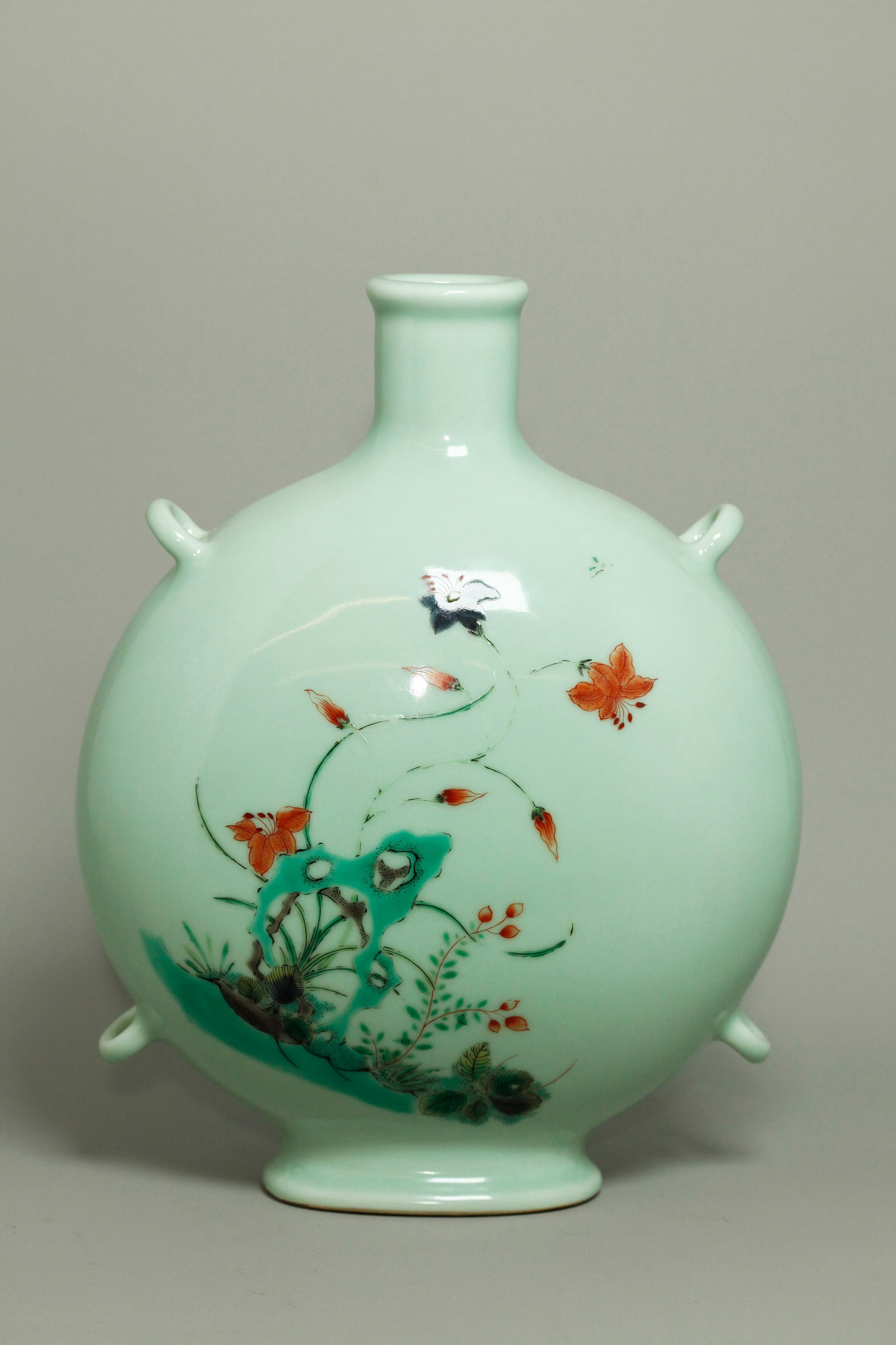 Chinese Enamel Celadon Glaze Porcelain Moon Flask: Chinese Enamel over Celadon Monochrome Glazed Porcelain Moon Flask with 4 loops to side edges for suspension, the front and back with overglaze wucai enamels of large Garden Rocks with Flowers and sma