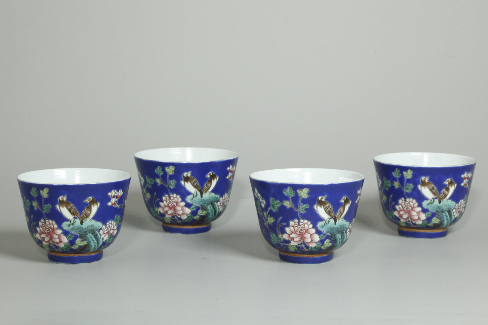 4 Chinese Qing Da Ya Zhai Blue Porcelain Cups: 4 Chinese Late Qing Dynasty "Da Ya Zhai type" Enameled Porcelain Cups with an outside design of 2 black birds on Garden Rocks with Peonies and Magnolia branches all on a cobalt blue enamel ground, the