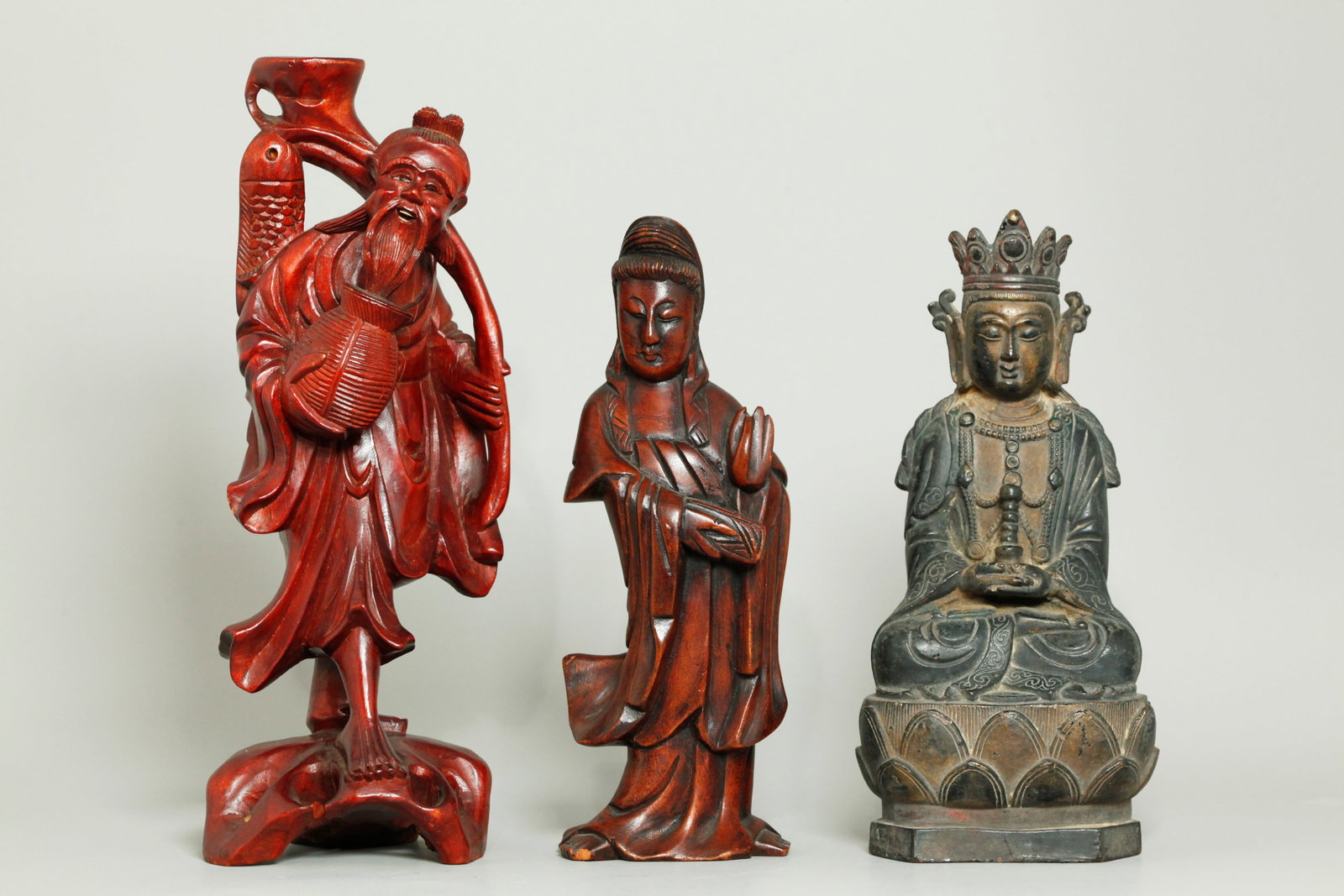 Chinese Bronze Buddha & Stupa; 2 Wood Carvings: Chinese Qing Dynasty cast bronze Buddha seated on a Lotus Throne open at the base and holding a small Stupa in hands; together with 2 wood carvings, the larger of a standing Fisherman with inlaid eyes