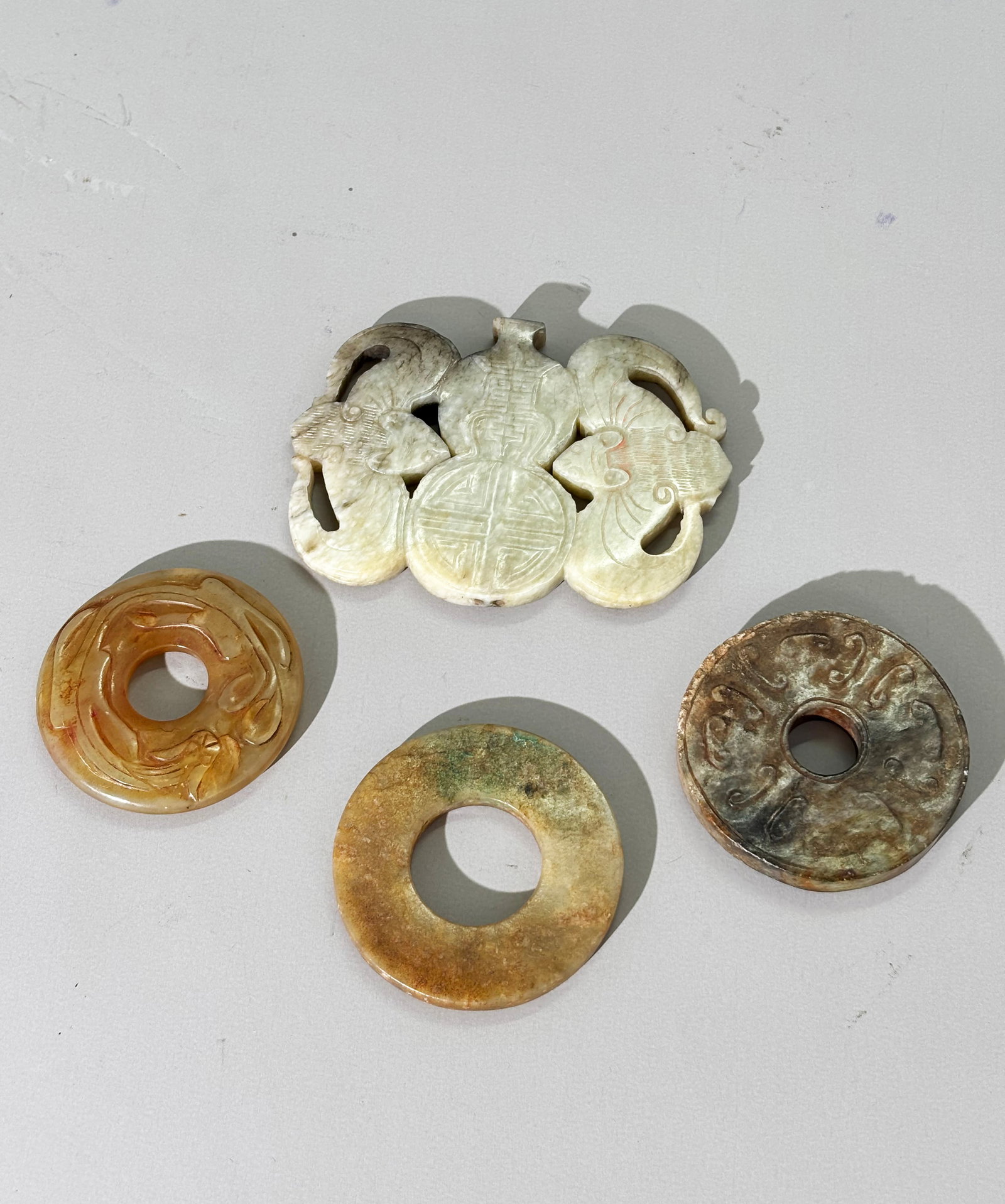 4 Chinese Antique Jades: Lg Pendant 3 Bi Rings: 4 Chinese Antique Jades: a Large 17th Century Pendant carved, pierced and polished from grey to brown with light calcification as a Shou Double Gourd flanked by 2 large Bats and with bull-nose holes t