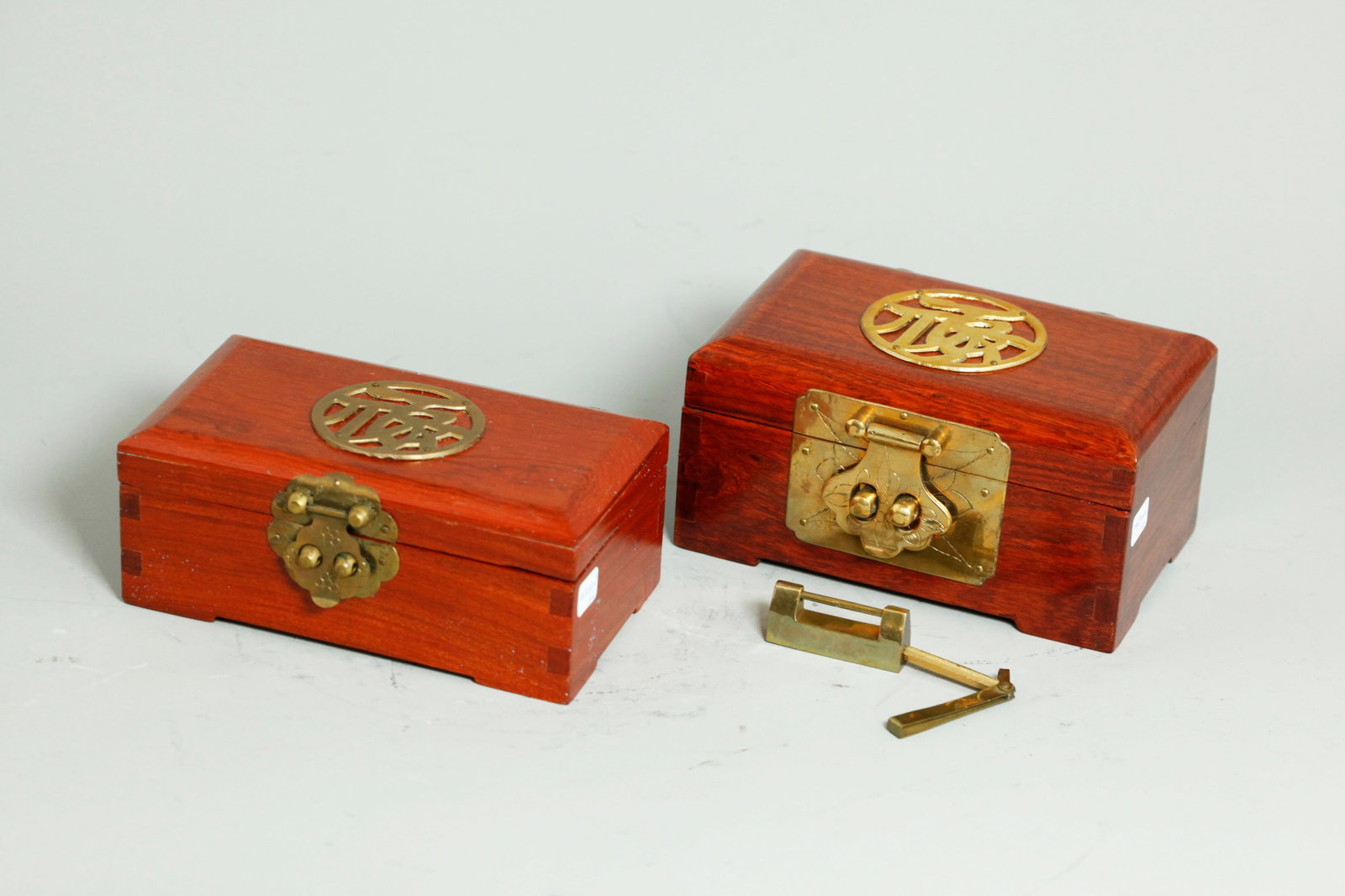 2 Chinese Vintage Hard Wood Jewel Boxes: 2 Chinese Vintage Yellow Hard Wood hinged Jewel Boxes, the larger with heavy bronze lock plate, lock and Key, with padded brocade interior with ring area; the smaller with wood separation forming 2 ha