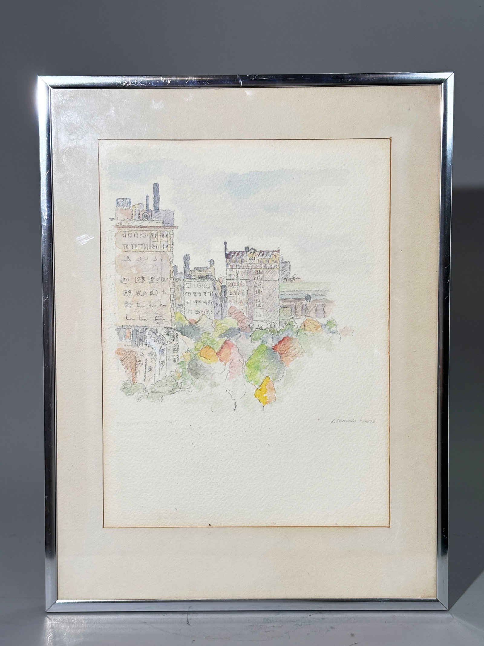 L Samuels; 1973 NYC Pencil & Watercolor Cityscape: L Samuels; signed & dated 1973 probably NYC, Pencil & Watercolor on watercolor paper matted & framed; a Cityscape of buildings around an unidentified park. Height of art 12'' x width 9'' PROVENANCE: P
