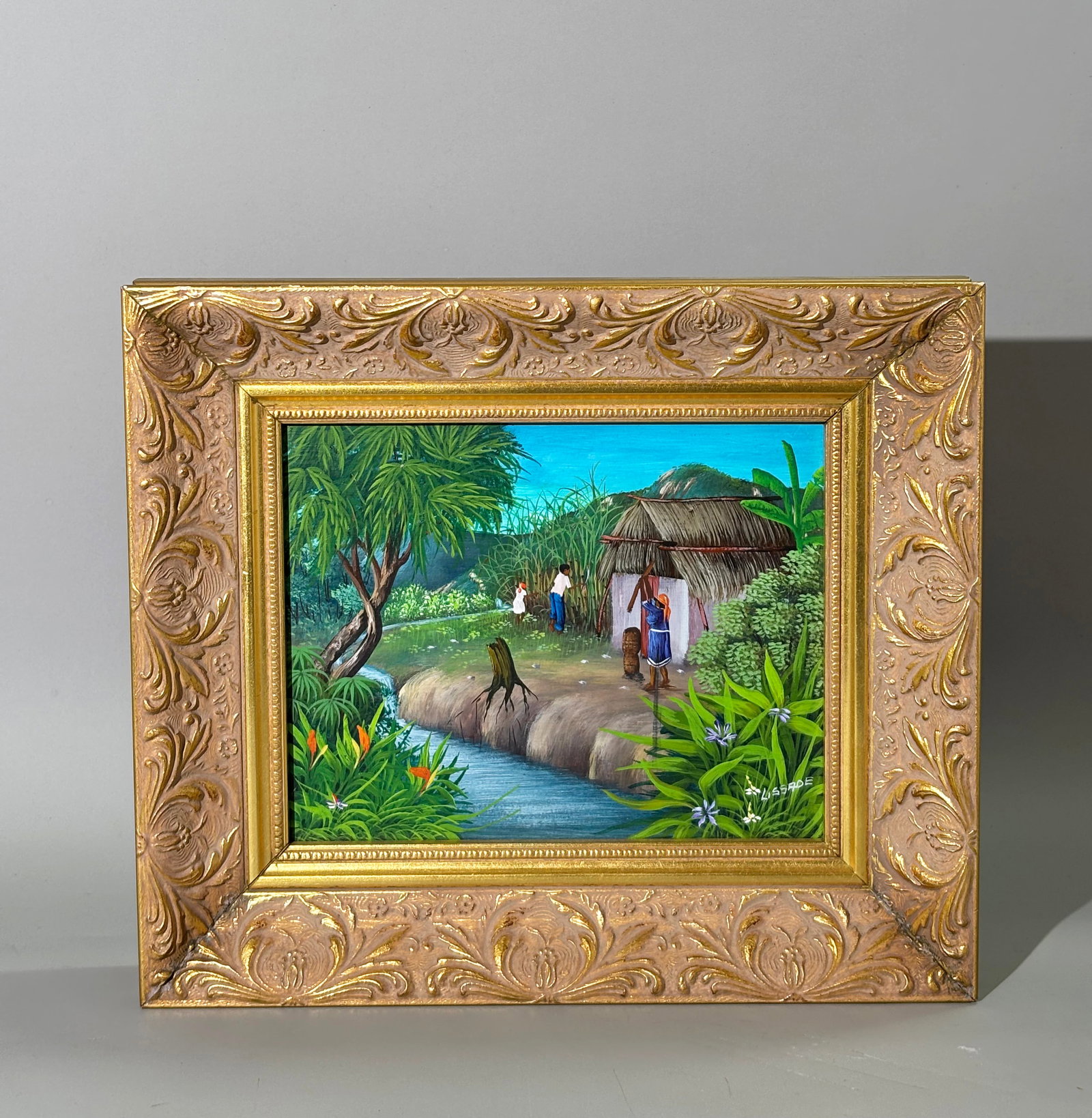 Lissade; Haitian Sugar Cane Farm; Gilt Frame: Lissade; Haitian Native Sugar Cane Farm Landscape in oil or acrylic on board signed "Lissade" to lower right corner recto; in an elaborate gilt Frame. Height of art 8 inches X width 9 3/4 inches. PROV