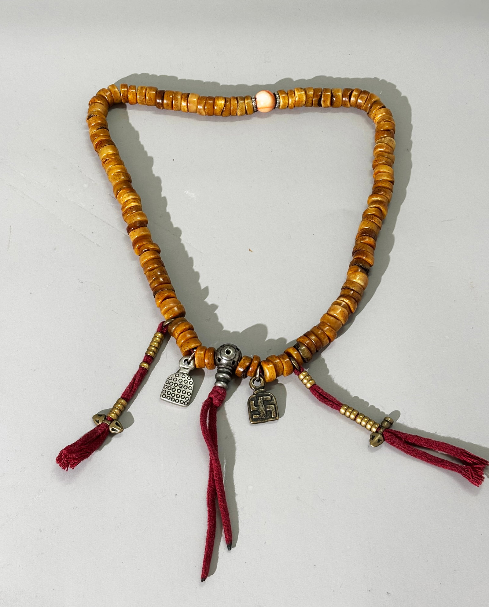 Tibetan 108 Old Bone Kapala Buddhist Rosary; 150G: Tibetan 108 Old Bone Kapala Buddhist Bead Rosary with small metal amulets and a coral 1/2 way bead. Total weight 150 grams. Length 23 1/2 inches.