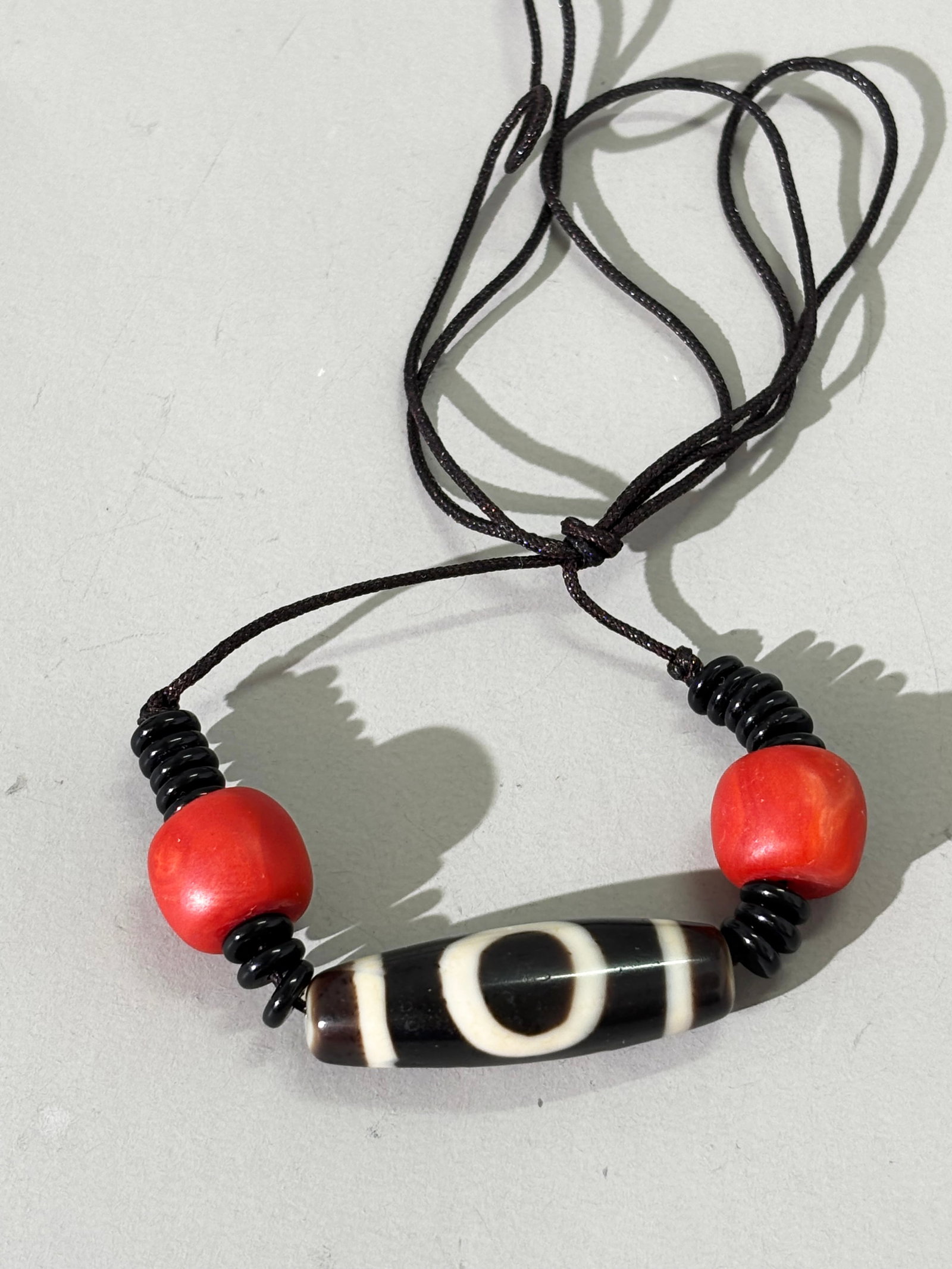 Tibetan Square & Circle Dzi Bead; 2 Corals; 13.6G: Tibetan Square & Circle Dzi Bead strung with 2 Corals. Total weight 13.6 grams. length 1 3/8''