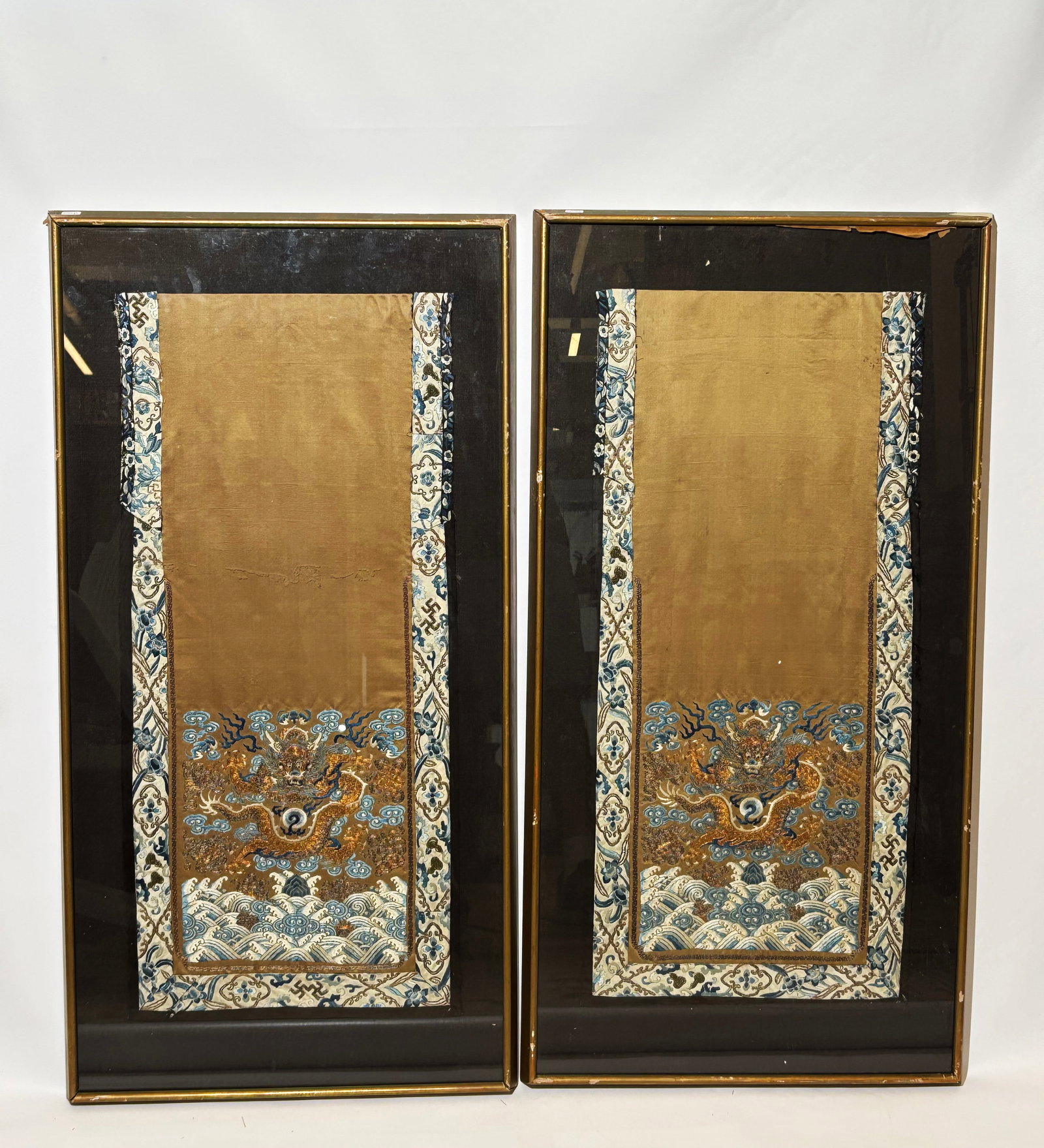 Pr Chinese 19th C Gold Embroidered Dragon Panels: Pair Chinese mid 19th Century Laid Gold & Silver Wrapped Thread Embroidered front-facing 5-claw Dragon Skirt Panels on dark yellow satin, the Dragons centered with a Flaming Pearl in clouds over blue 