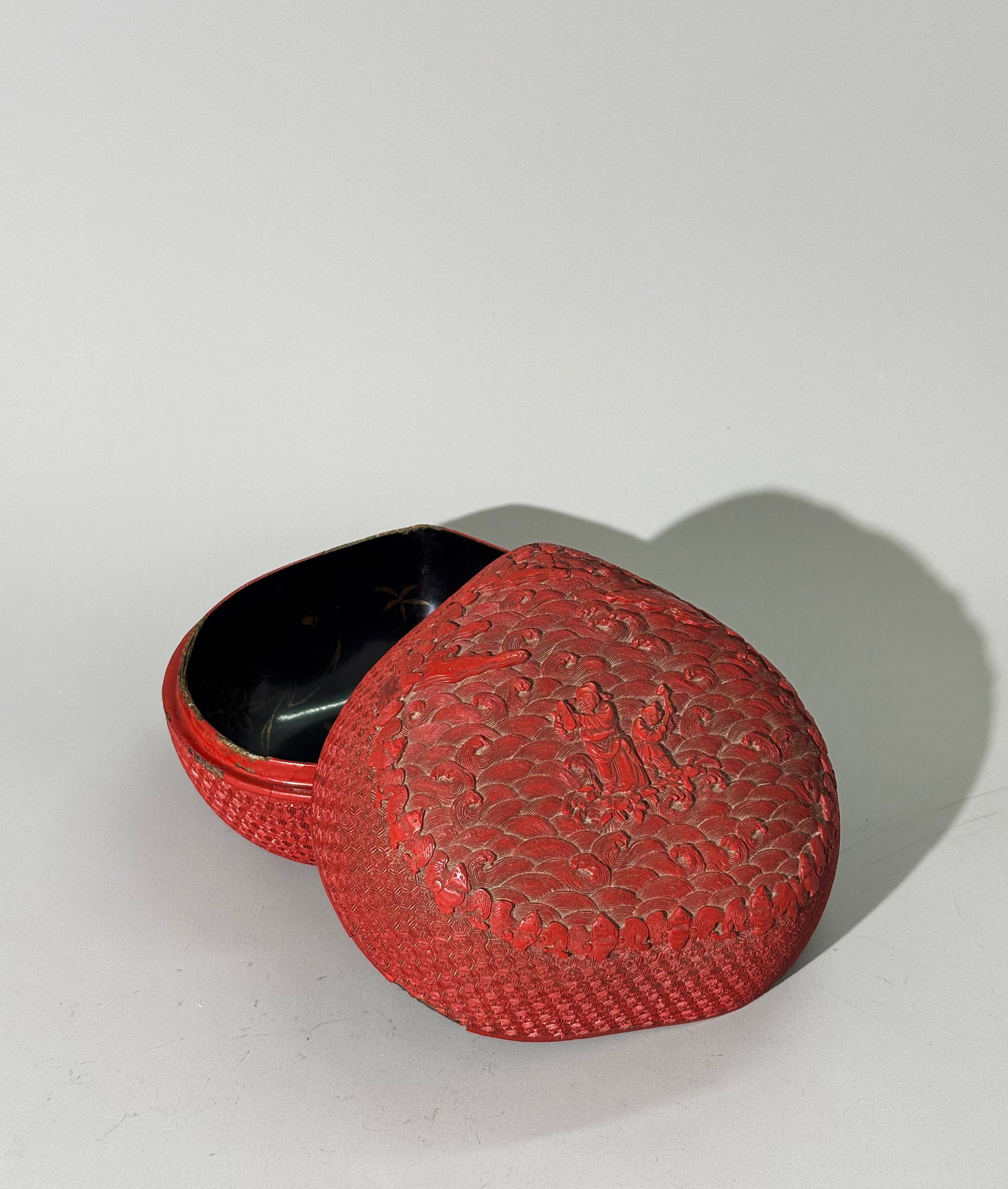 Chinese 18th C Red Cinnabar Lacquer Peach Box: Chinese 18th Century Red Cinnabar Lacquer Peach Box, the cover well carved with 2 Immortals, Cao Guojiu with clappers (Paiban) and Lan Caihe with stem of lingzhi, both in the center of elaborately car