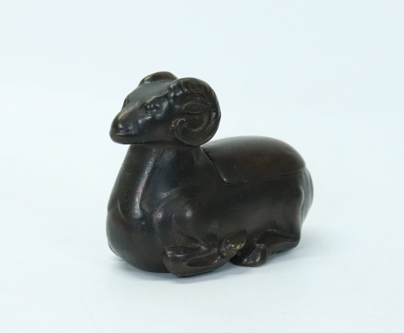Chinese Ming Heavy Bronze Ram Oil Lamp: Chinese Ming or possibly earlier, Heavy-Cast Bronze Ram Oil Lamp, the back hinged forward with a candle prick inside; dark patina. Height 2 3/4'' x Width 3 1/2''.