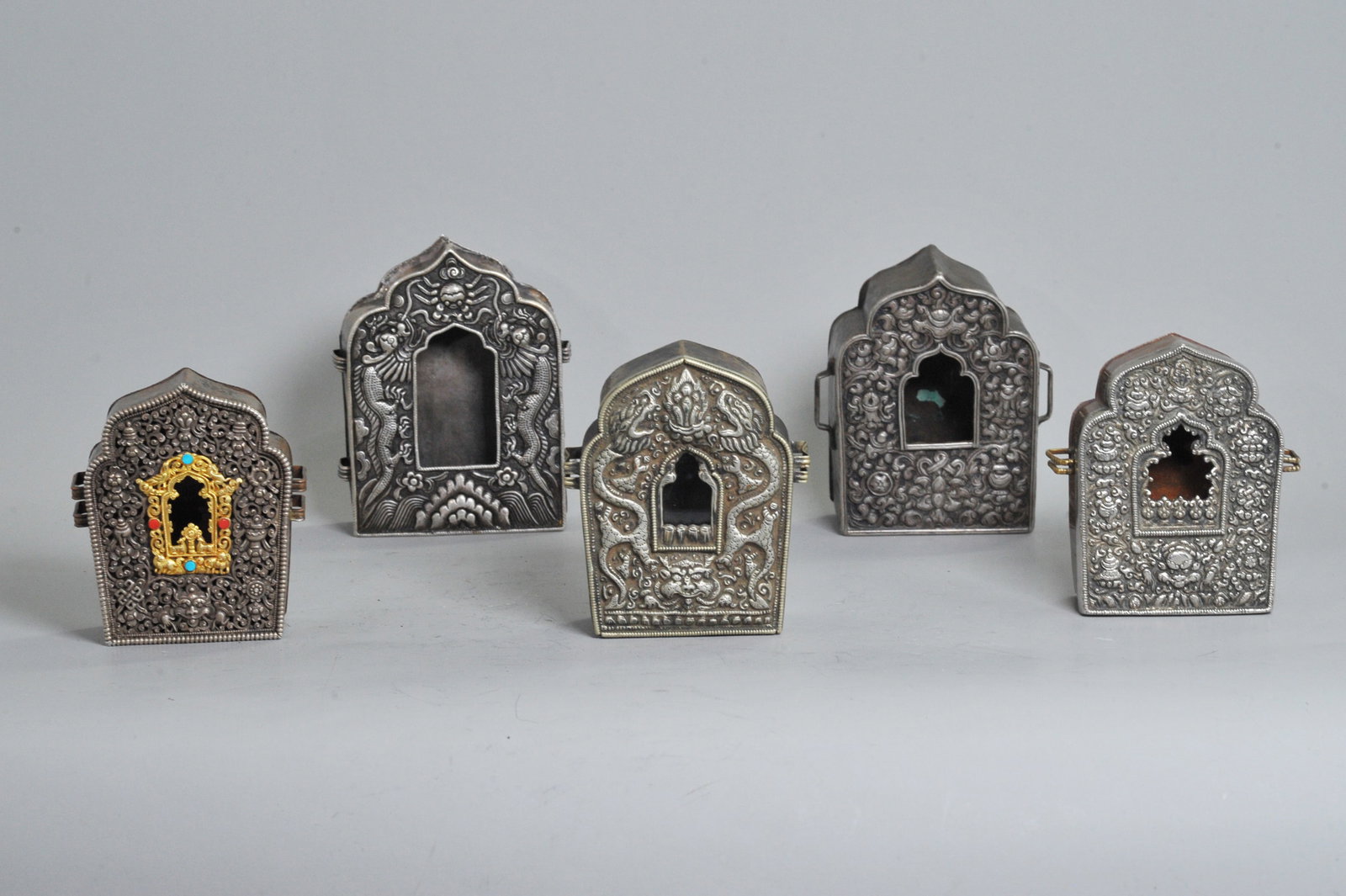5 Good Tibetan Repousse Silver Front Gao Boxes: 5 Good Tibetan Incised and Repousse Silver Fronted Gao Boxes each with side loops for strap attachment, all but 1 missing original glass to front window; the largest with silver sides and sliding silv