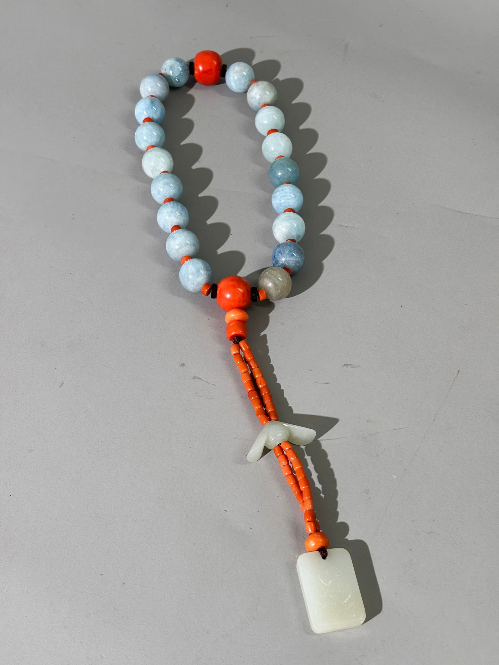 Chinese 18 Bead Buddhist Rosary Bracelet: Chinese 18 Bead Buddhist Rosary Bracelet in pale blue translucent crystal, probably tourmaline beads strung with small coral spacers and with 2 large coral end beads with a double string of small cora