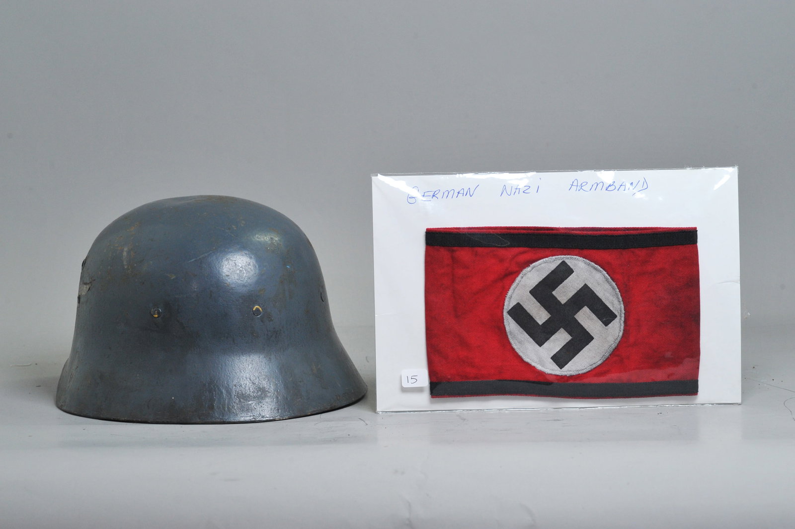 German Luftwaffe Double Decal Helmet, Red Armband: German Luftwaffe Double Decal Helmet in field grey finish, featuring an eagle-and-swastika decal on the left and a tricolor national shield decal on the right. The interior is fitted with a complete l