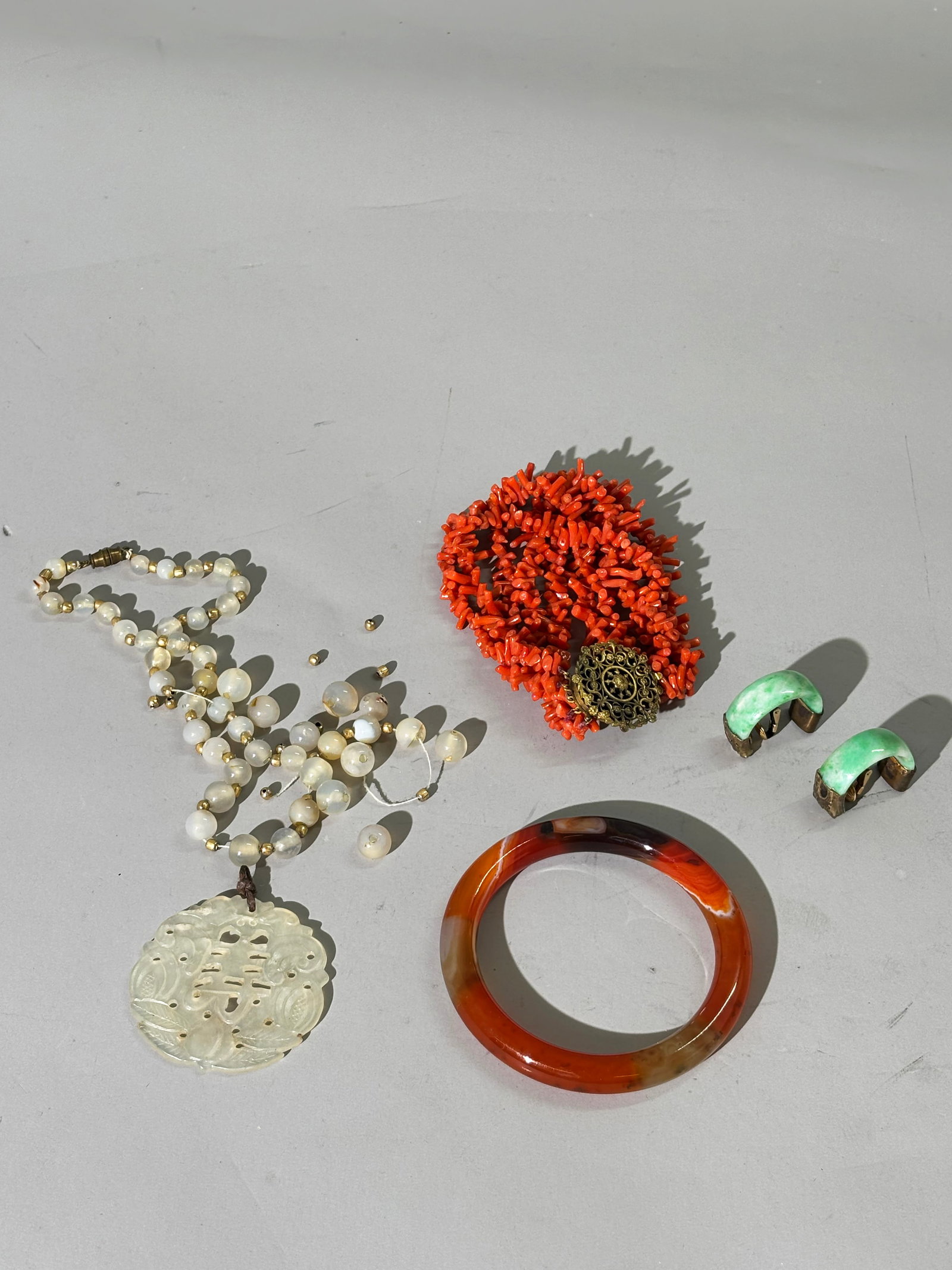 Chinese Jadeite Earring, Coral Bracelet & More: Vintage 5 Strand Branch Coral Bracelet; gilt Filigree Closure. Total weight 50 grams. Length 8 1/2 inches. and Chinese Qing Dynasty Apple Green Jadeite 1/2 Ring Earrings with antique gilt metal mounts