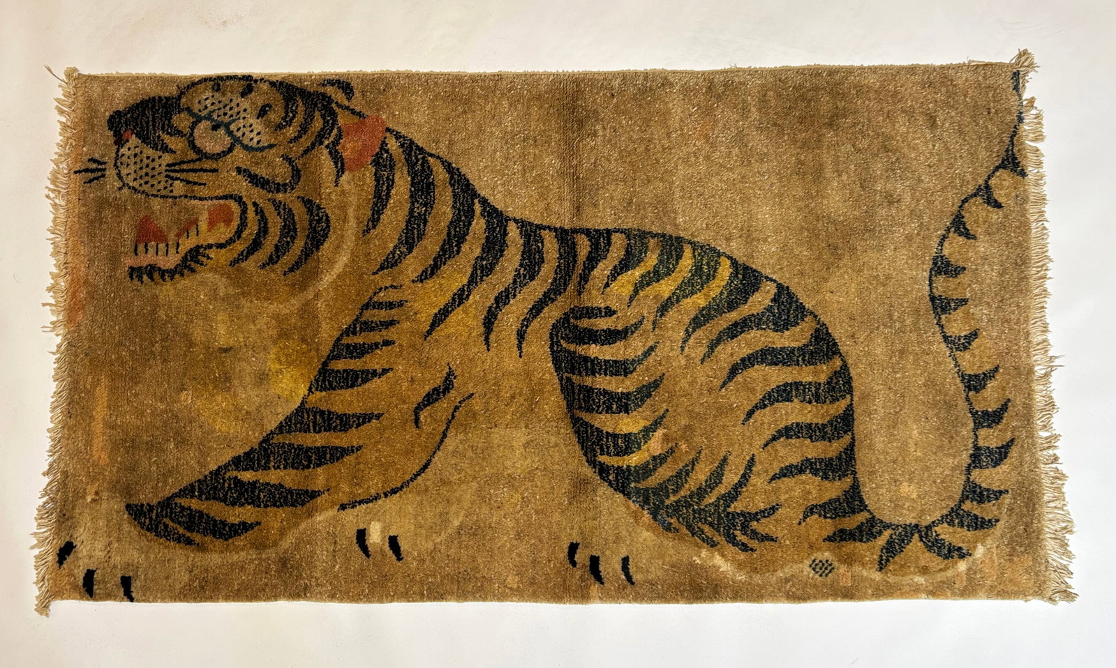 Antique Tibetan Tiger Wool Carpet: Antique Tibetan Tiger Wool Carpet, the fringe ends missing with slight unraveling of pile to create new fringe. Length 43 1/2 inches X width 23 1/2 inches.