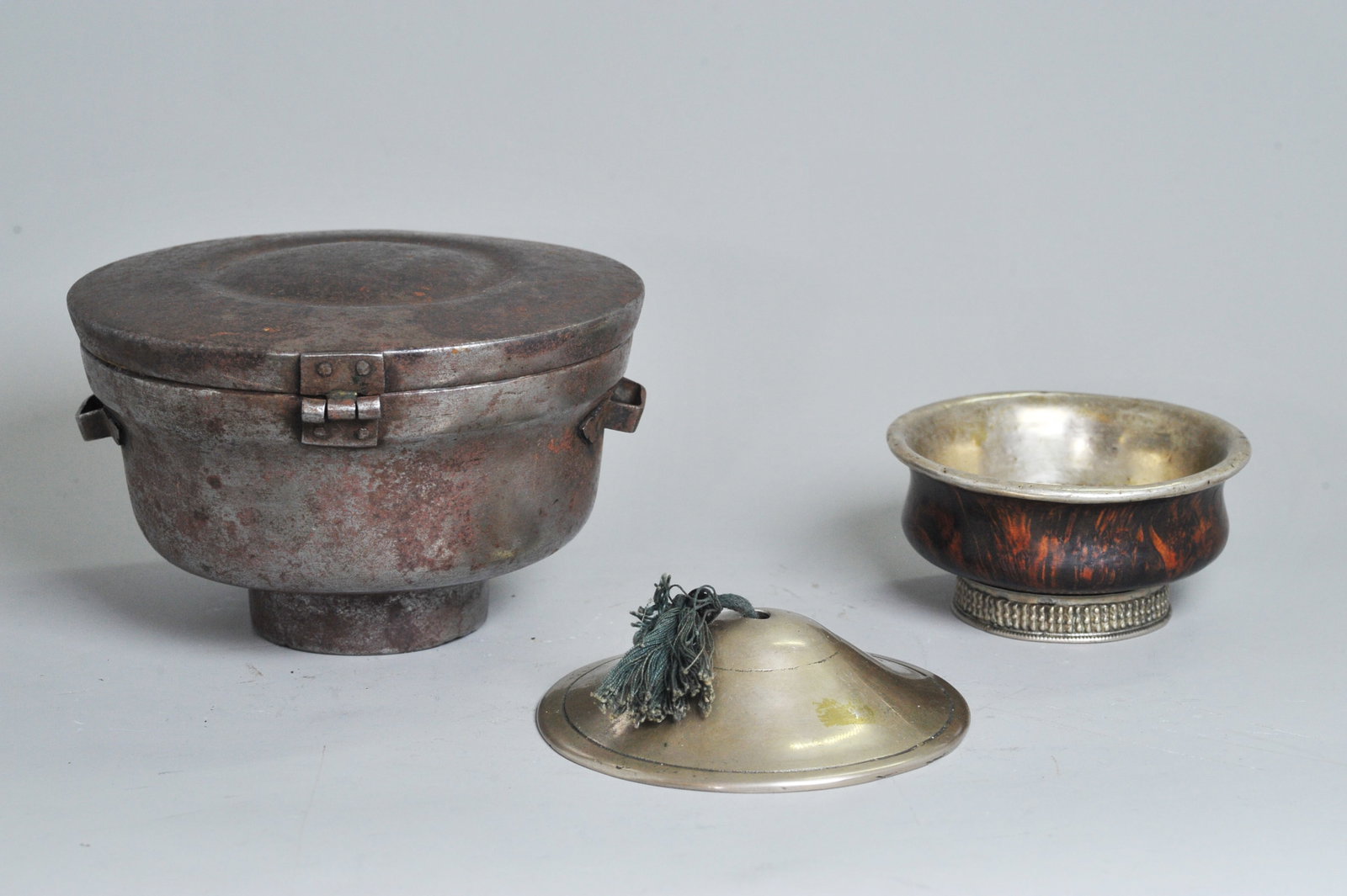 Tibetan 19C Iron Ritual Bowl Case Burl Bowl & Gong: Tibetan 19th Century Iron Ritual Bowl Case with hinged cover and side straps for suspension; together with a Burl Bowl with silver lining inside and around foot ring and a white bronze Meditation Gong