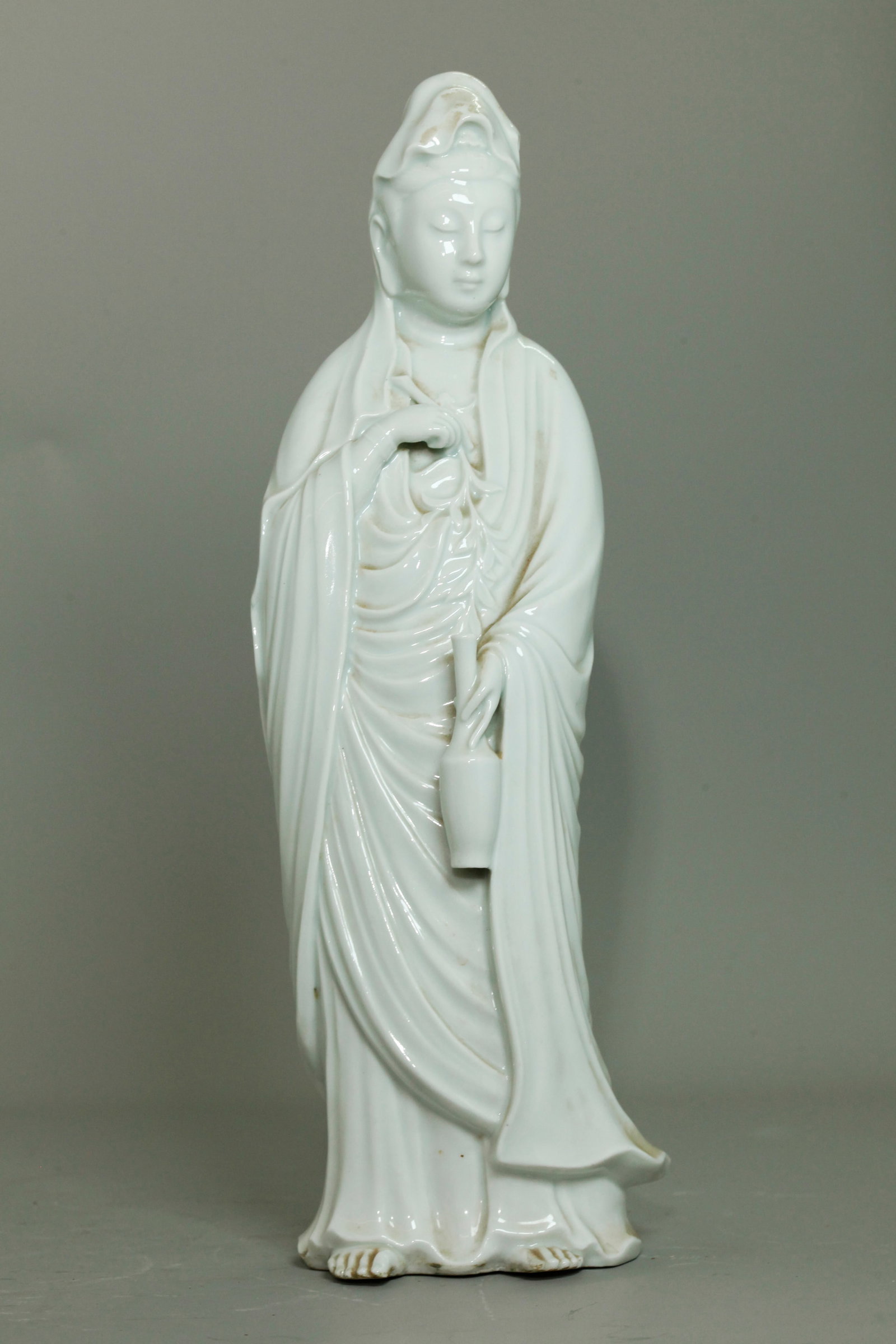 Chinese Blanc De Chine Porcelain Standing Guanyin: Chinese Blanc De Chine Porcelain Standing Guanyin holding a leafy branch in her right hand and a vase of compassion in her left hand. Height 6 1/2 inches X width 5 inches.